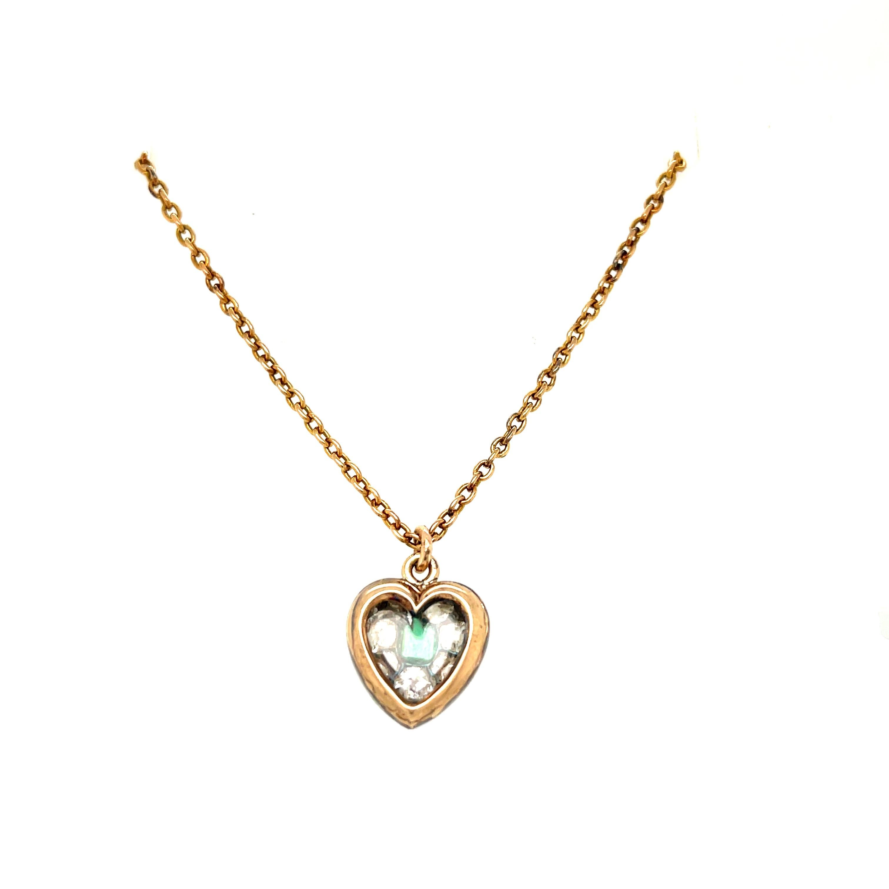 An antique silver topped 15k gold old mine diamond heart pendant set with a square cut emerald, circa 1880. This sweet heart is set with 31 old mine cut diamonds that are H to J color and VS to SI quality - approximately 1.80 carats. The larger