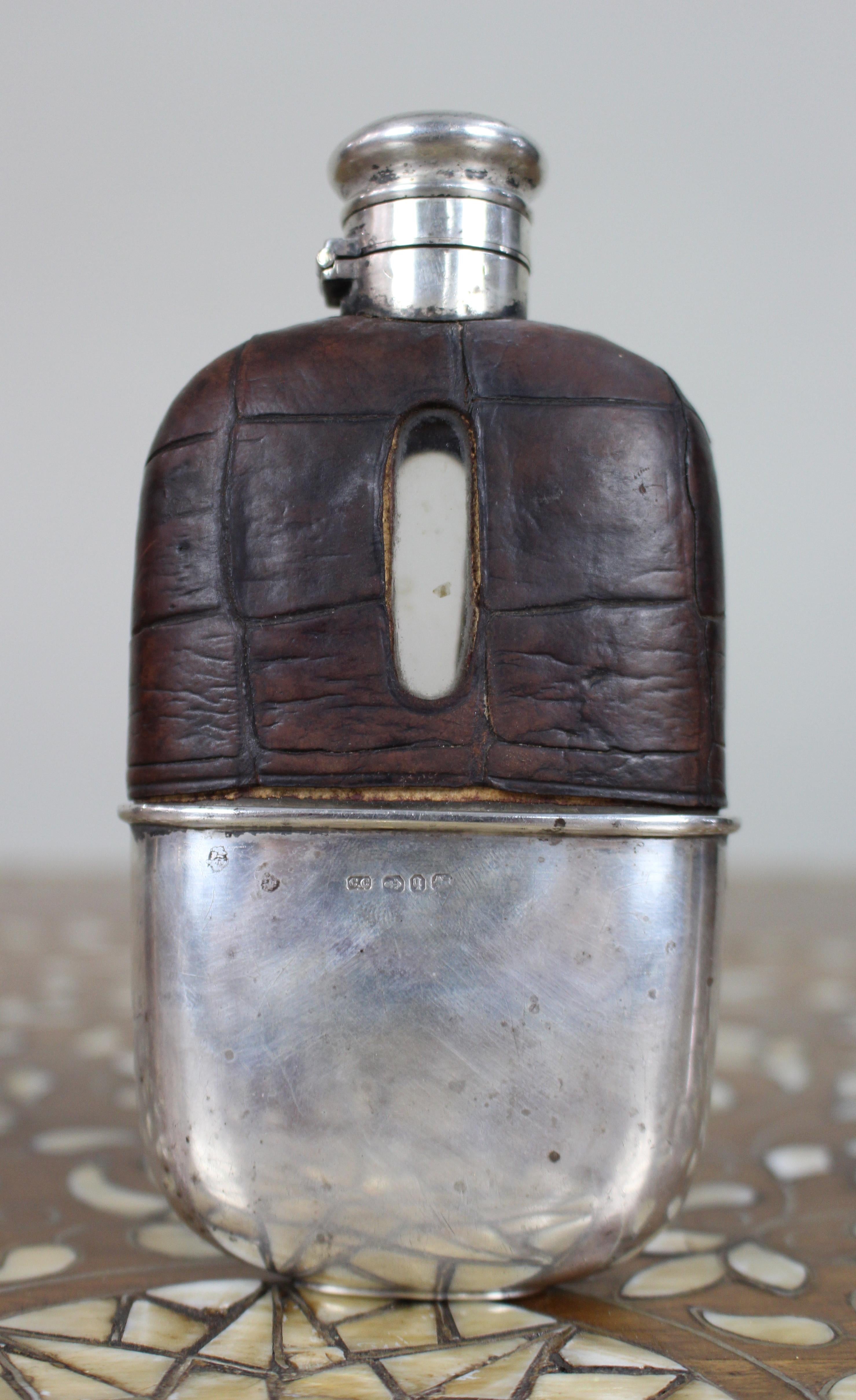 Antique Victorian Silver & Leather Hip Flask – Birmingham 1890/91

A fine Victorian silver-mounted hip flask, hallmarked for Birmingham, 1890 (cup) and 1891 (lid), by Colen Hewer Cheshire.

The body is glass, clad in dark brown crocodile leather