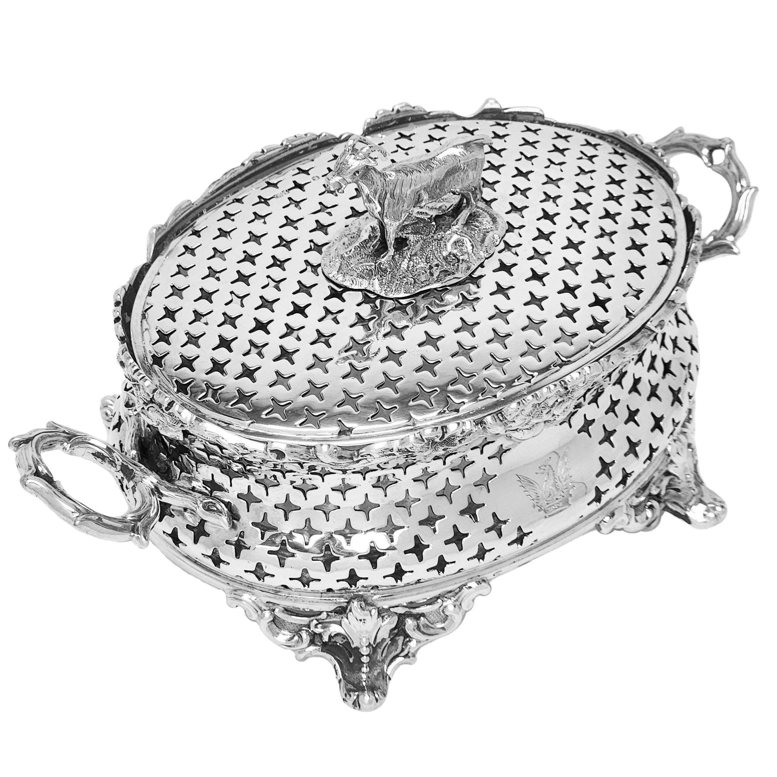 A lovely Antique Victorian Silver Butter Dish with a glass liner. This Lidded Victorian Butter Dish has an elegant pierced pattern on the body and lid. The lid is topped with a goat shaped finial and the base stands on four ornate feet. The Oval