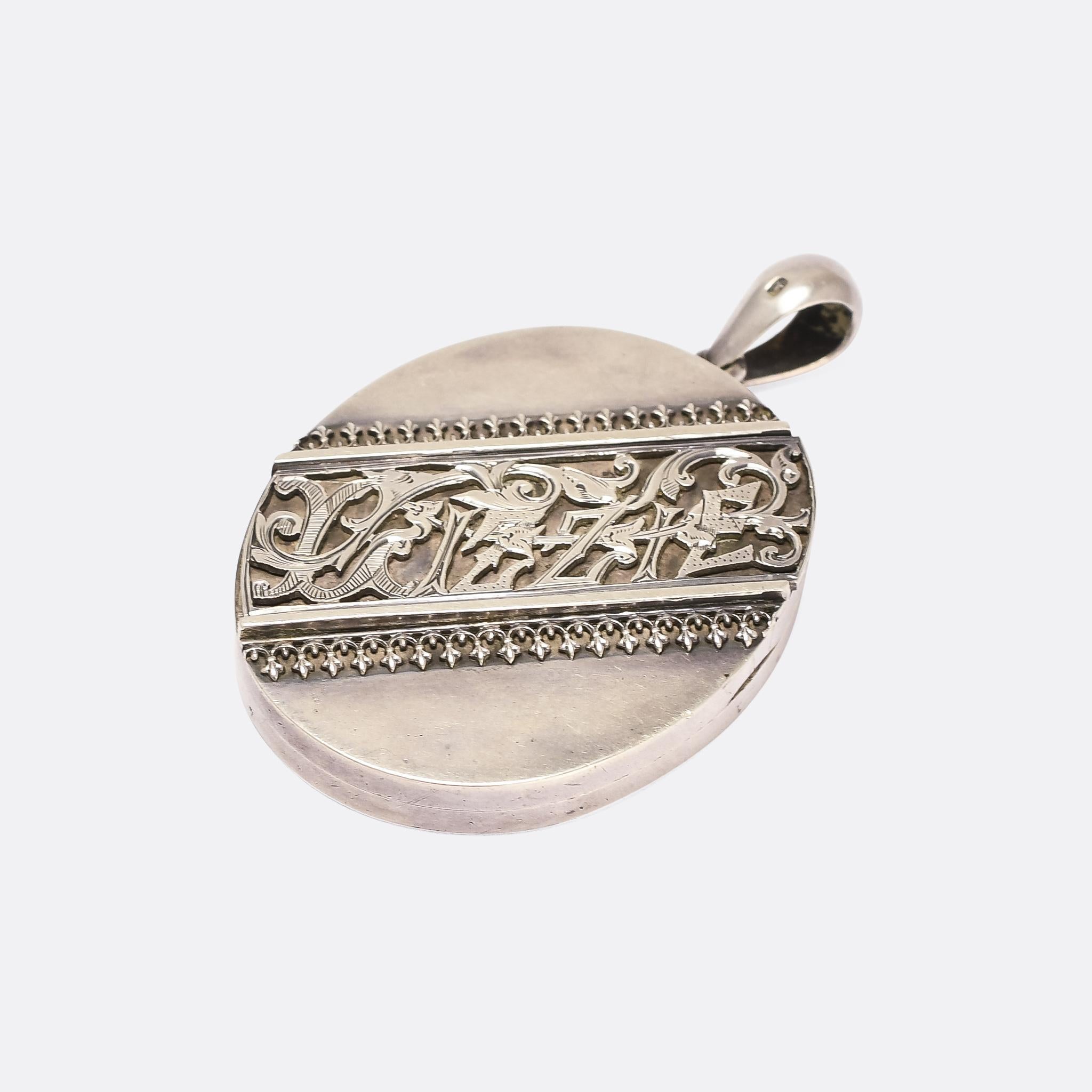 A cool Victorian oval locket with the name Lizzie emblazoned across the front. The lettering is beautifully worked, and decorated with rococo style acanthus leaves. It's crafted in sterling silver, with clear Birmingham hallmarks dating it to the
