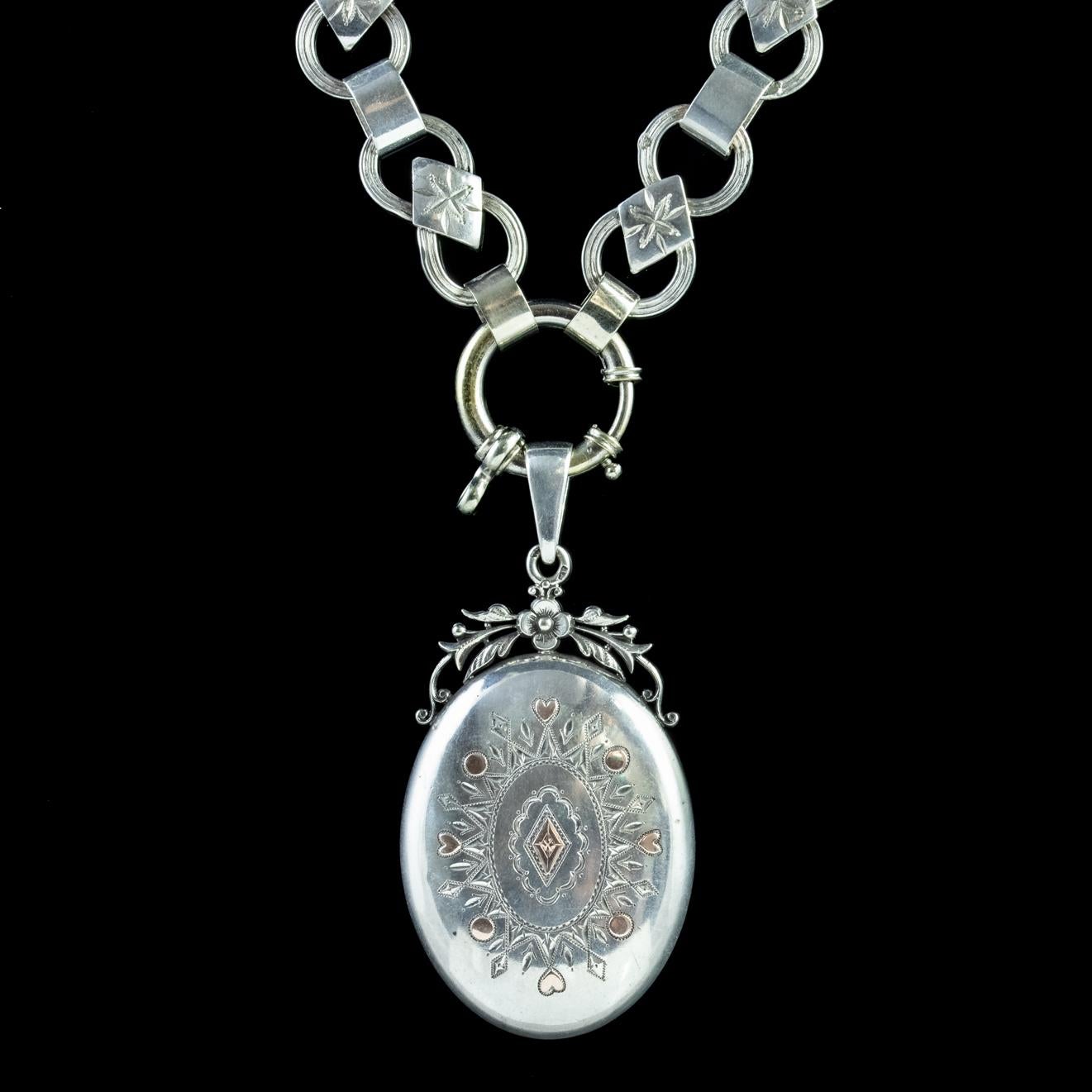 A grand antique Victorian necklace showcasing a beautiful Silver locket with an engraved design on the front tipped with Rose Gold highlights and a fabulous floral metalwork below the bale.

The locket on the reverse opens and closes securely with