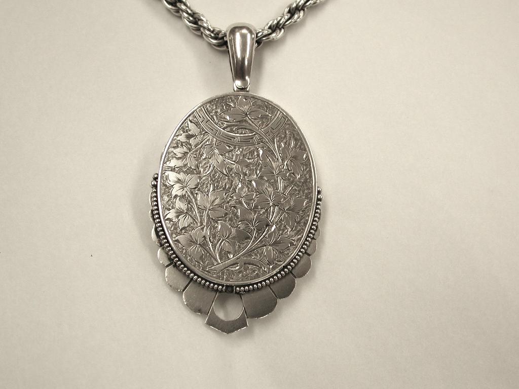 Antique Victorian Silver Locket  dated circa 1880.
Typically hand engraved with a delicate beaded border, with sturdy heavy gauge 
 second hand silver solid silver prince of wales rope chain, probably dated 1960's and marked 925 sterling.