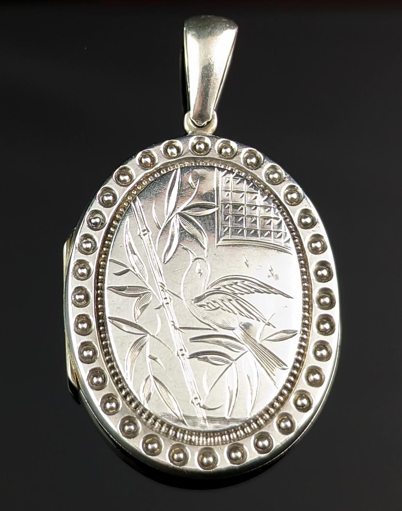 Diese schöne antike viktorianische Sterling Silber Medaillon Anhänger ist so hübsch und süß mit seinem attraktiven und interessanten Design.

Auf der Vorderseite ist in ästhetischer Weise ein Paradiesvogel inmitten von Blättern eingraviert, die