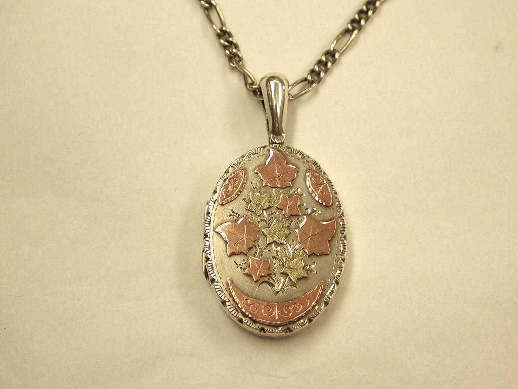 Antique Victorian Silver Locket with Applied  9ct Goldwork, 1887, Sydenham Bros.
Good quality Silver locket with 2 colour goldwork on old venetian link 19 inch silver chain.
Fitted for 2 photographs inside with silver retainers.