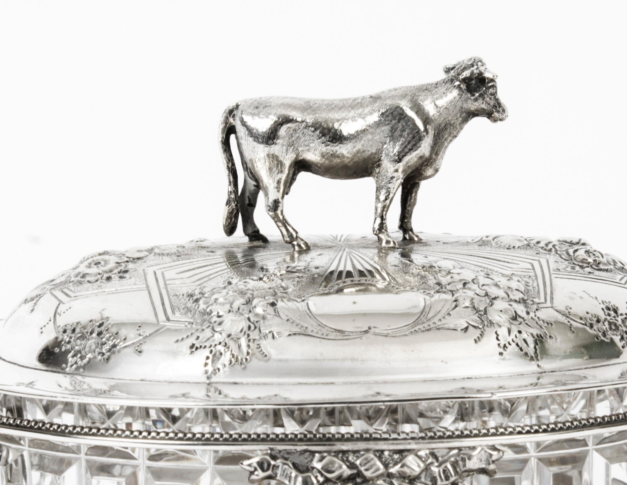 This is a fine antique Victorian silver plated and cut glass lined butter dish, on stand by the renowned silversmith Martin Hall and Circa 1880 in date.
 
The lid features neo-classical decoration with a standing cow and it has a cut glass liner