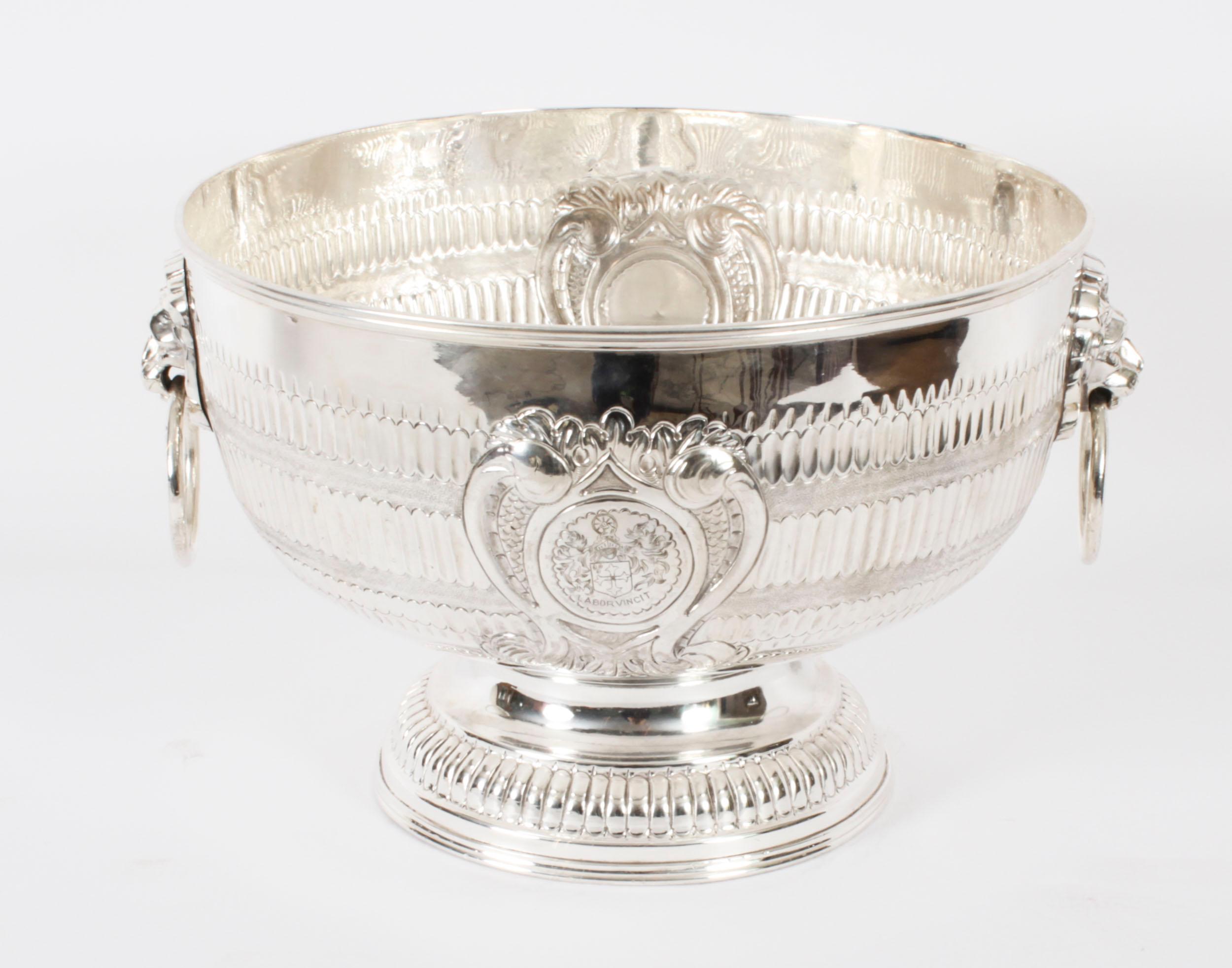 This is a gorgeous large antique Victorian silver plate on copper pedestal punch bowl or wine cooler,  Circa 1860 in date.
 
This exquisite punch bowl has beautiful fluted hammered decoration with two lion mask capped loop handles, each bearing an