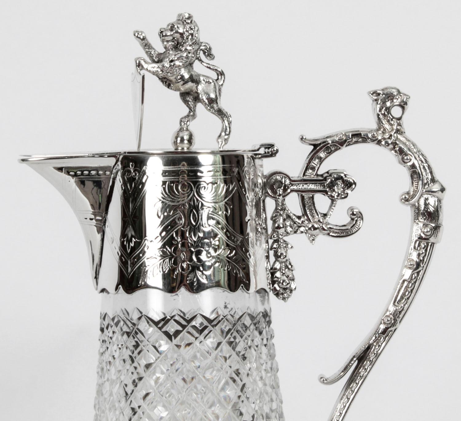 This is a wonderful Antique Victorian cut glass and silver plated claret jug,  Circa 1870 in date

The flared, diamond and prismatic cut glass body below a foliate chased mount, with lion and shield finial and an ornate scroll handle with leopard