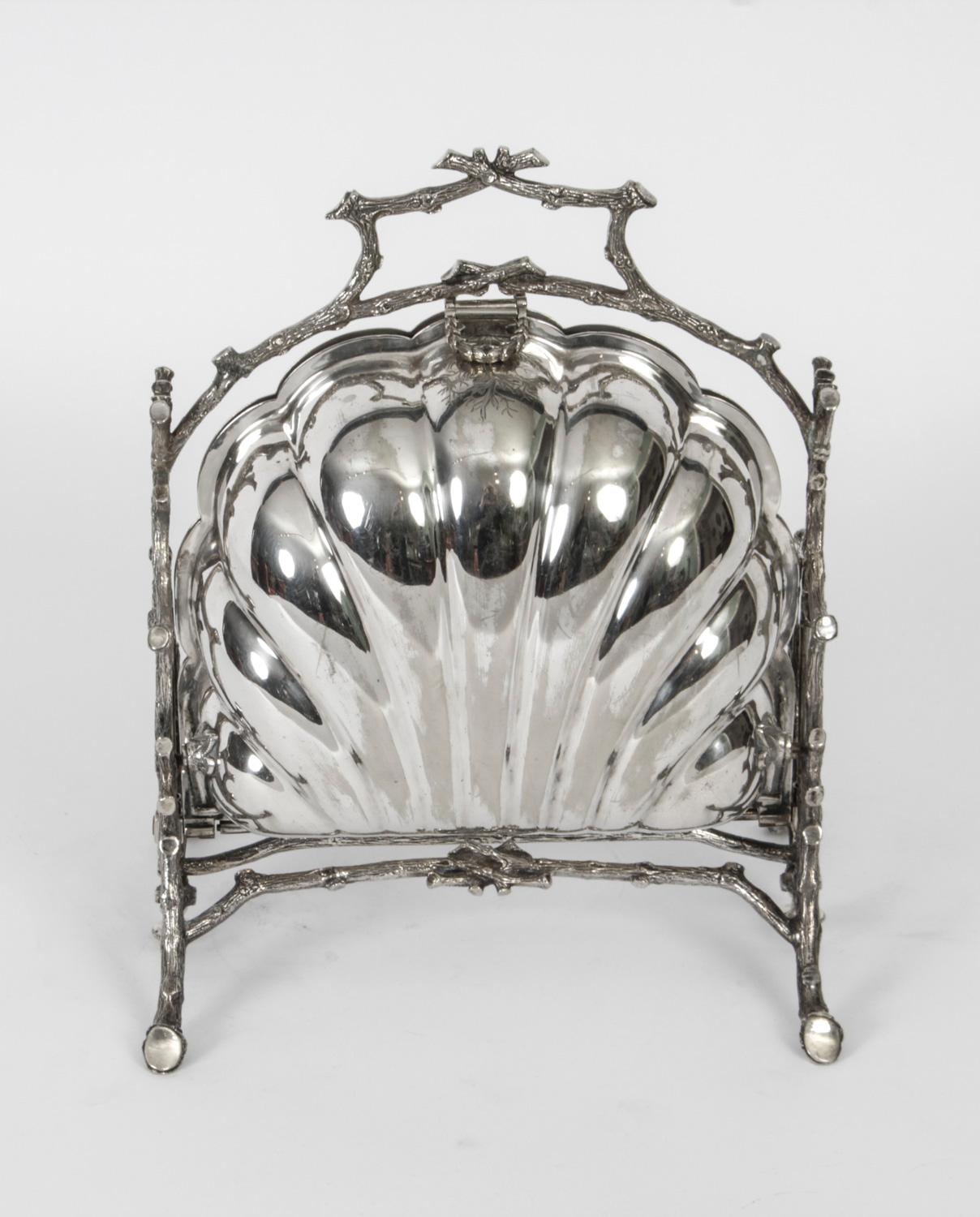 This is a highly decorative antique Victorian silver plated folding biscuit box, circa 1880 in date.

It has a beautifully shaped body sitting in a cast frame with remarkably chased branch supports and the original interior features elegant