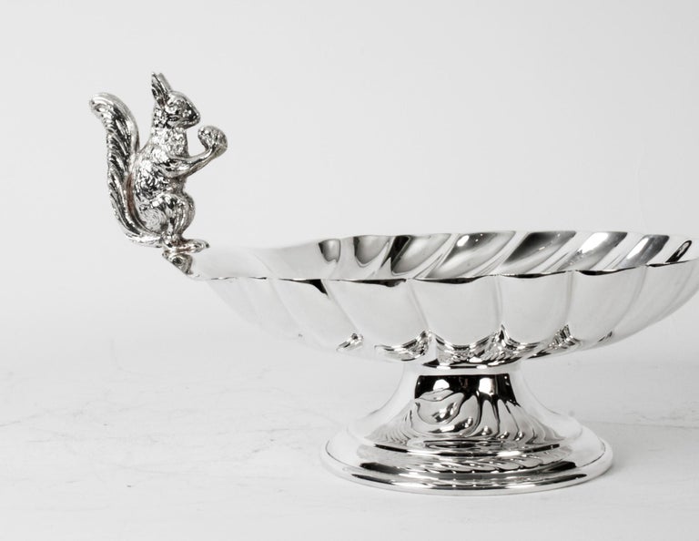 This is a stunning antique English Victorian silver plated nut dish or sweet dish, by the silversmith William Hutton & Sons of Sheffield with the Crossarrows mark and dated C 1880.
 
It features a fabulous embossed body and has a squirell eating a