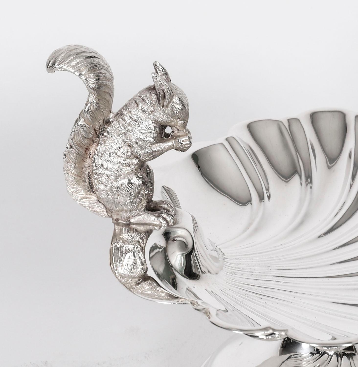 This is a stunning antique English Victorian silver plated nut dish or sweet dish, marked Sheffield, circa 1880.

It features a fabulous shell embossed body and has a squirel eating a nut whilst balanced on one end, the shell is raised on a round