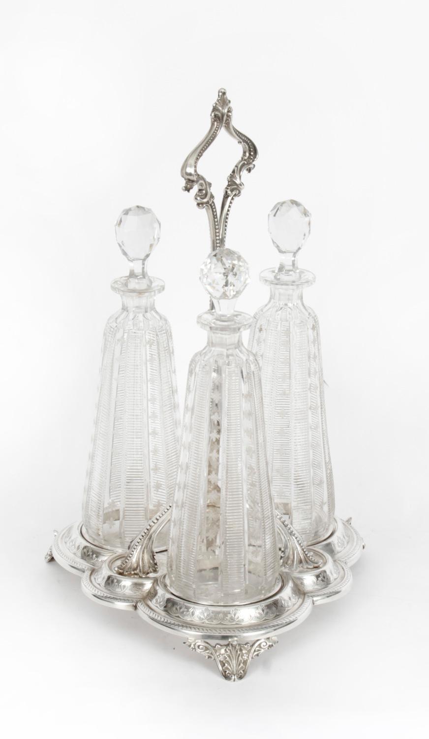 Il s'agit d'un très joli tantale victorien ancien en métal argenté avec trois carafes et bouchons en verre taillé, datant d'environ 1860.
 
Les trois carafes en verre taillé sont de forme inhabituelle et présentent une superbe décoration linéaire