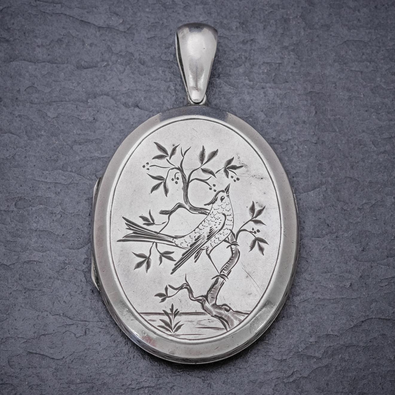 An exquisite Antique mid-Victorian locket displaying a beautiful engraved image of a swallow perched on a tree branch on the front and fabulous foliate patterning and Forget me nots on the reverse.  

Swallows were a popular image in Victorian