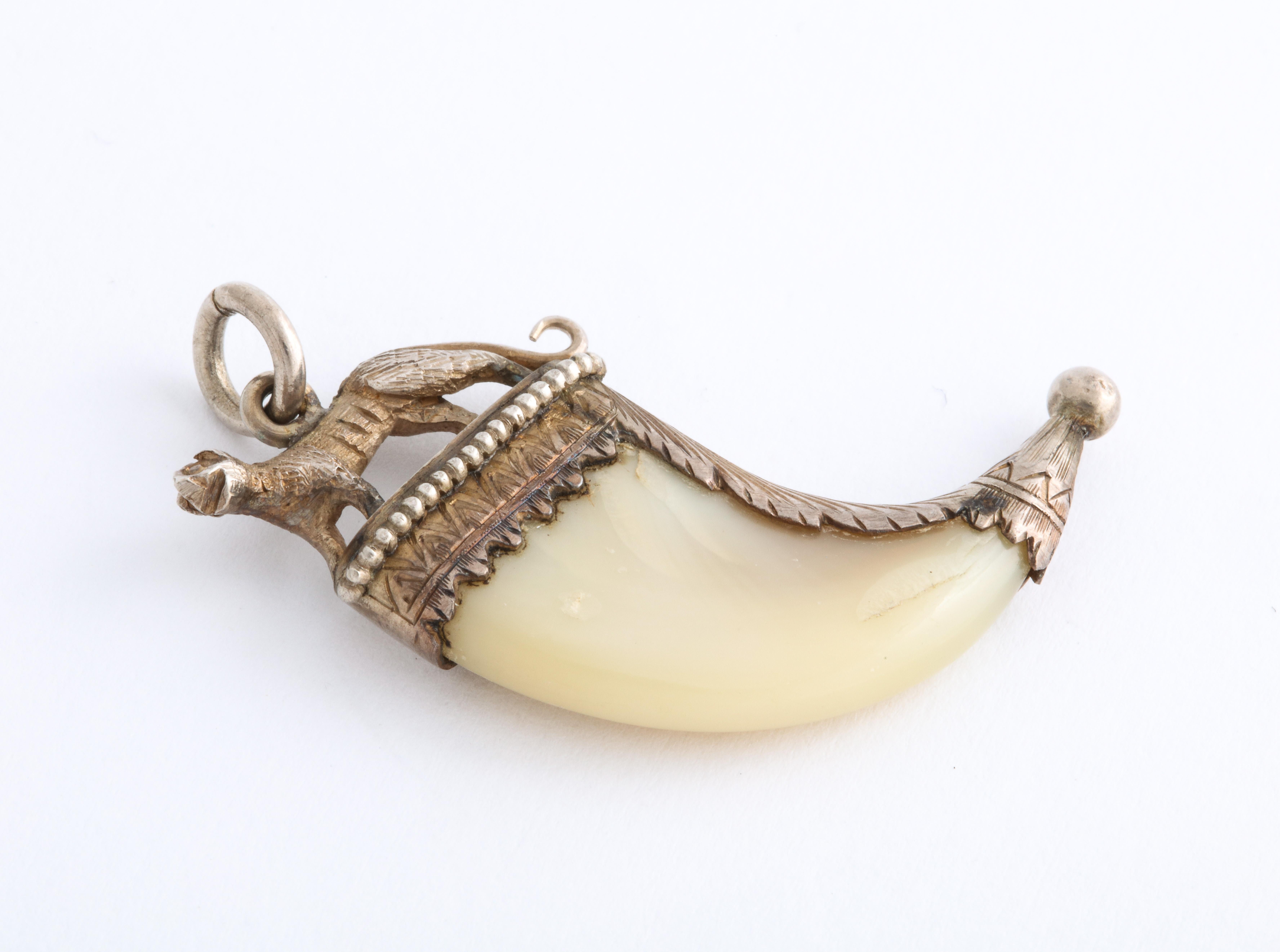 There are instances when a small pendant has enormous interest and this silver trimmed tiger claw pendant is such a piece. Notice the beading at top that puts the animal on a pedestal. Note the three dimensional tiger and the engraving on the silver