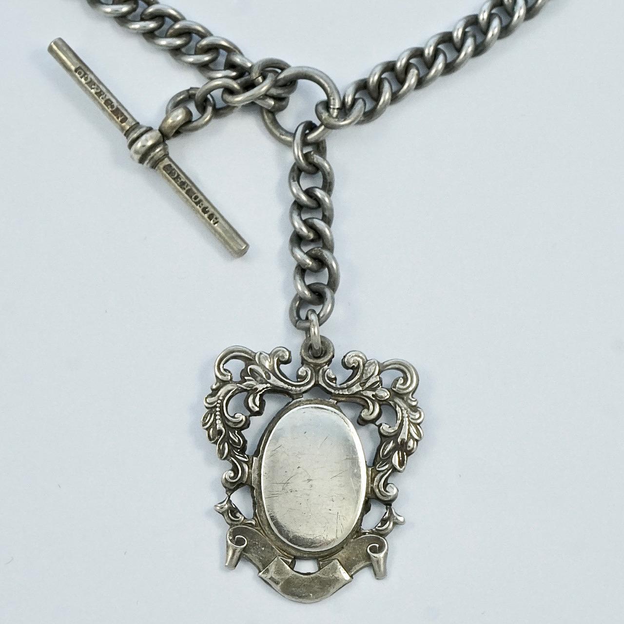 Antique Victorian silver tone double Albert watch chain, with a lovely decorative fob. Measuring length 37.8 cm / 14.88 inches. It is stamped NCR & Co for N C Reading & Co of Birmingham, England, and ALBO registered. 

This wonderful antique watch