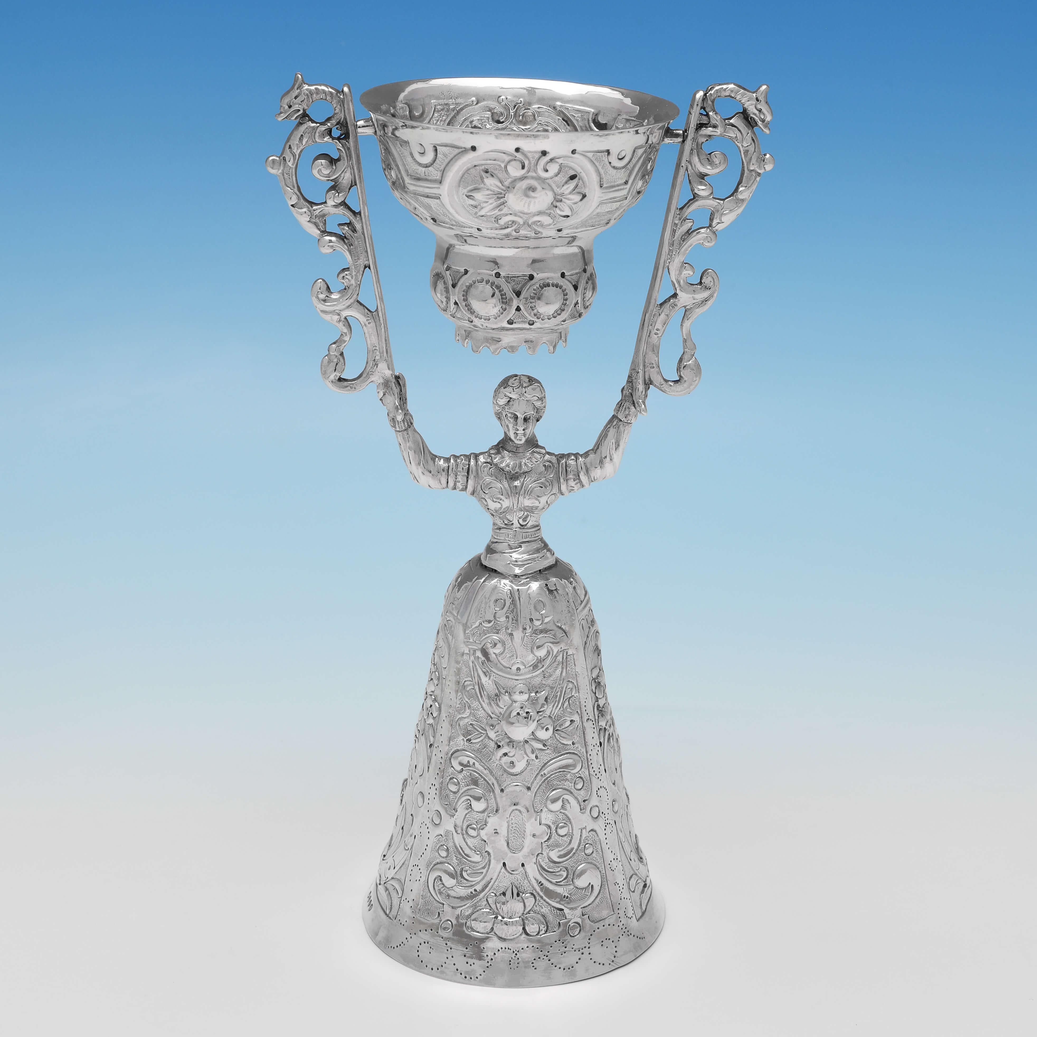 Carrying import marks for London in 1891 by Martin Sugar, this striking pair of antique sterling silver wager cups, are modelled as a gentleman and a lady in costume, and feature chased decoration throughout. Each wager cup measures 7