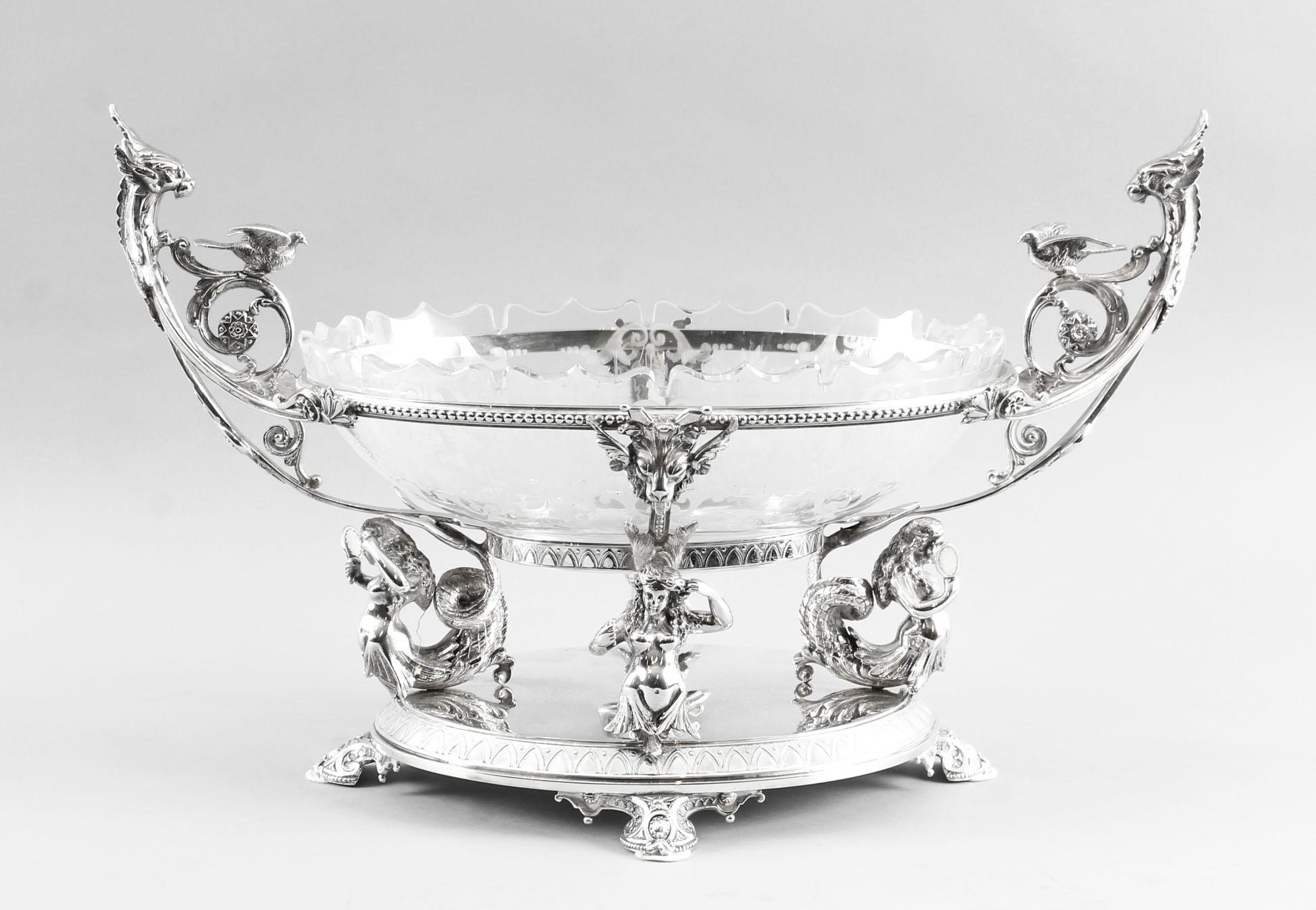 This is an intricate and exquisitely made antique silver-plated Victorian centrepiece by the renowned silversmith, Henry Wilkinson & Co, circa 1870 in date.
This stunning centrepiece has a central oval glass dish which is beautifully engraved and