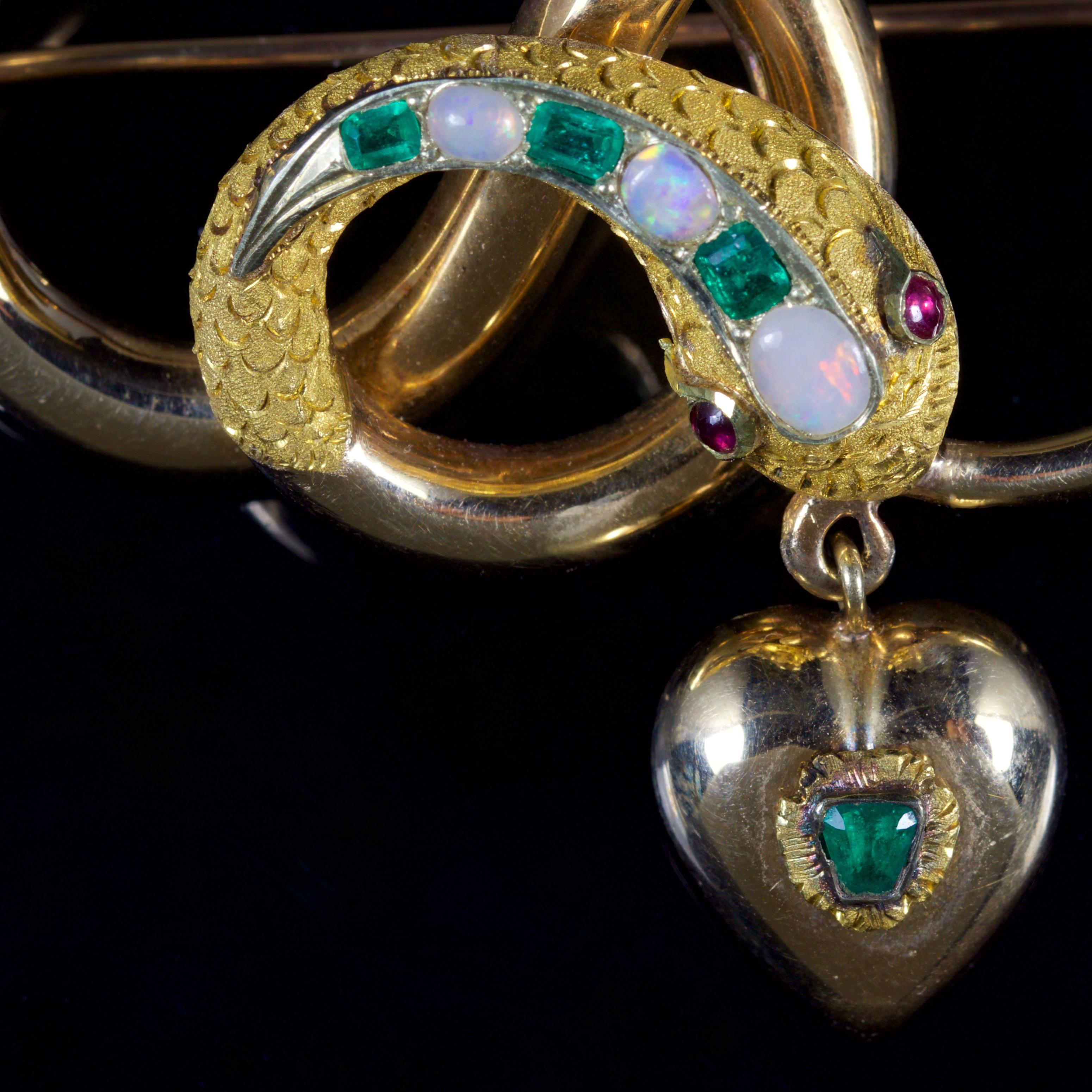 This fabulous antique Victorian 18ct Gold snake brooch is Circa 1860.

The wonderful brooch depicts a beautifully engraved 18ct Gold snake which is adorned with Emeralds, Opals and Rubies.

The Rubies are the snakes eyes, with the beautiful Emeralds
