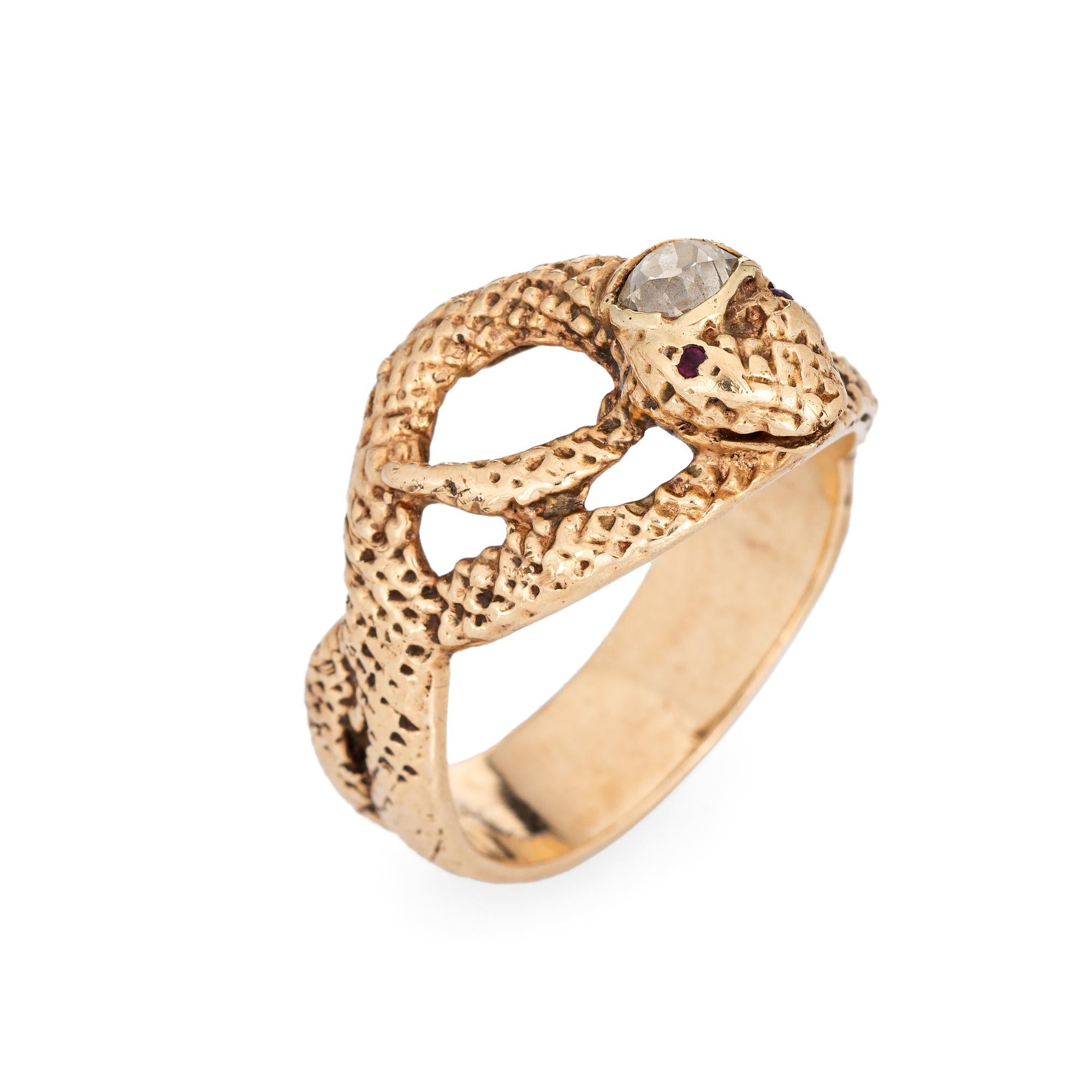 Finely detailed antique Victorian coiled diamond snake ring, crafted in 14 karat yellow gold (circa 1880s to 1900s). 

Old mine cut diamond is estimated at 0.25 carats (estimated at L-M color and SI2 clarity). Two red paste stones are estimated at