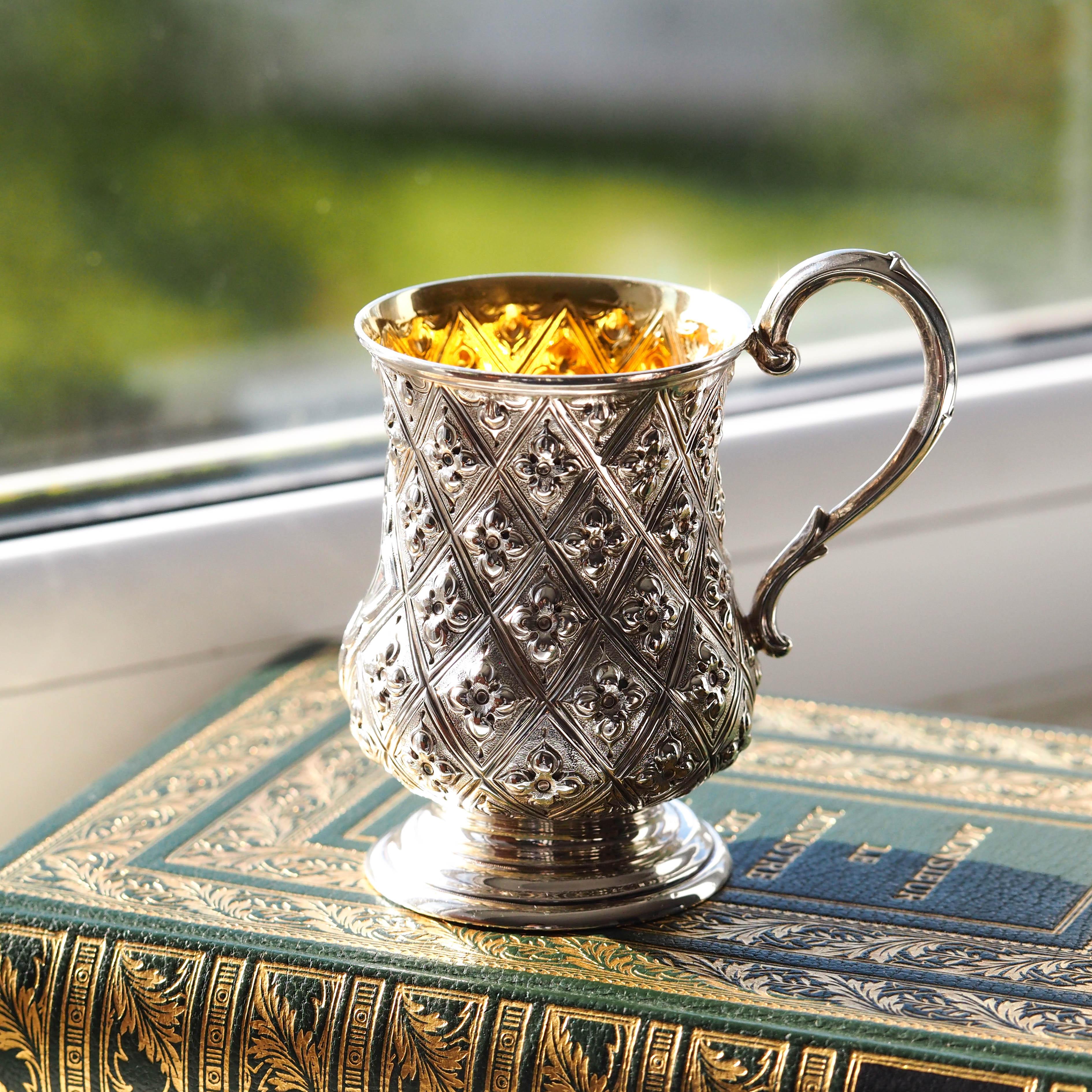 We are delighted to offer this beautiful and decorative Victorian solid silver mug cup made in London by Martin, Hall & Co 1868. 

This piece is a fabulous example of a modestly sized yet exquisitely decorated Victorian mug which is not only