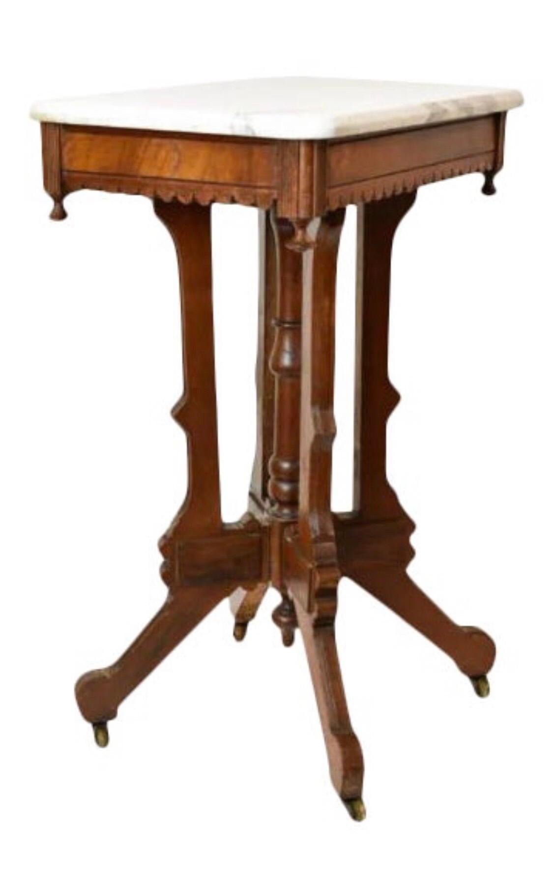 Circa 1890 walnut side table features a carved apron and turned center pedestal. It measures 30-1/2