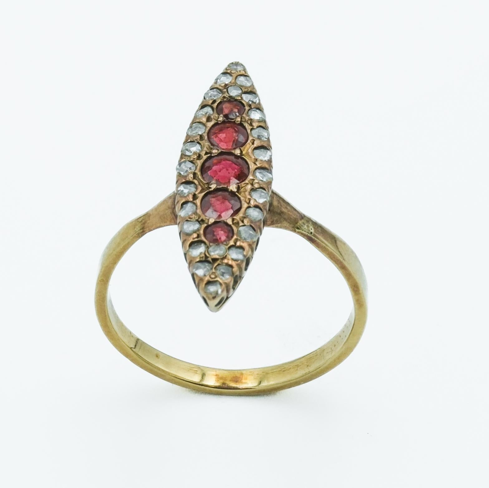 This beautiful Antique Victorian Navette Ring features spinel and diamond set in 10 karat gold. The navette-shaped design is adorned with vibrant red spinels surrounded by a halo of rose cut diamonds. The detailed craftsmanship of the Victorian era