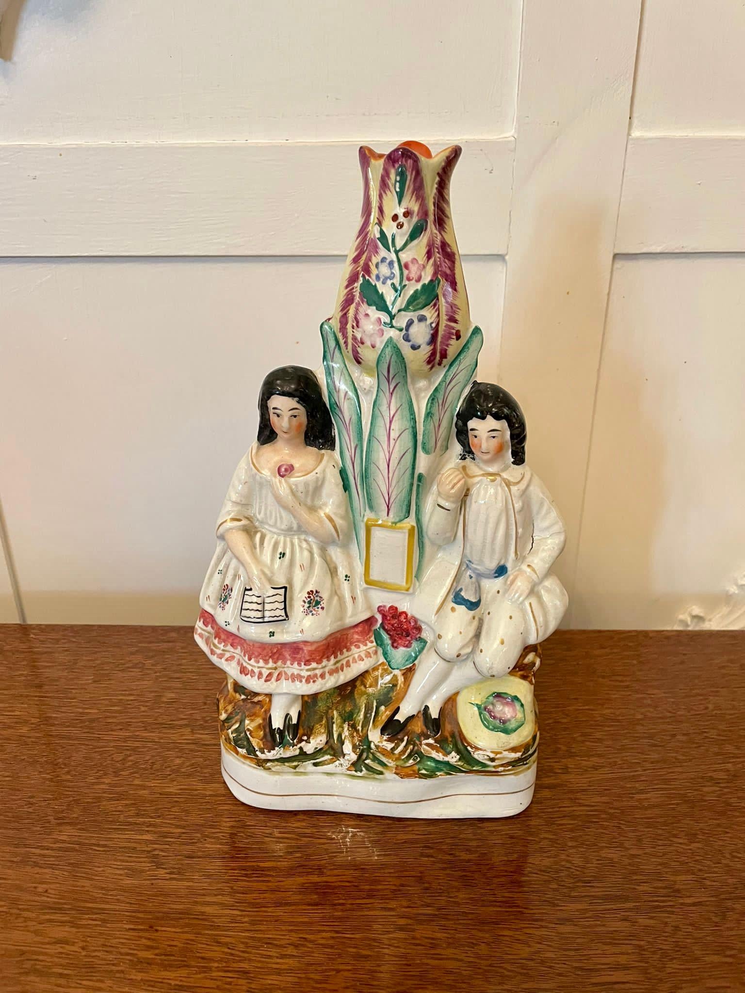 Antique Victorian Staffordshire figures of a lady and gentleman in period clothing between a colourful tree.

Measures: H 27.5cm 
W 17cm 
D 7cm
Date 1860.
   