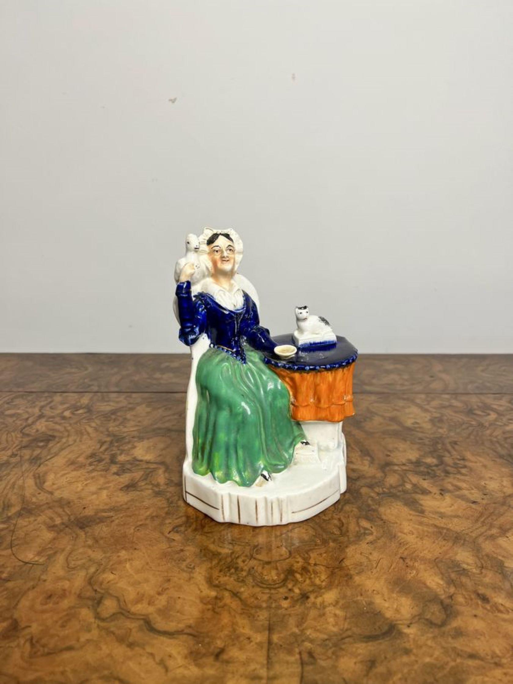 Antike viktorianische Staffordshire-Gruppe mit einer sitzenden Dame mit einem Vogel auf der Schulter und einer Katze auf dem Tisch neben ihr, handbemalt in wunderschönen grünen, blauen, orangen und weißen Farben, auf einem geformten Sockel. 

D. 1880