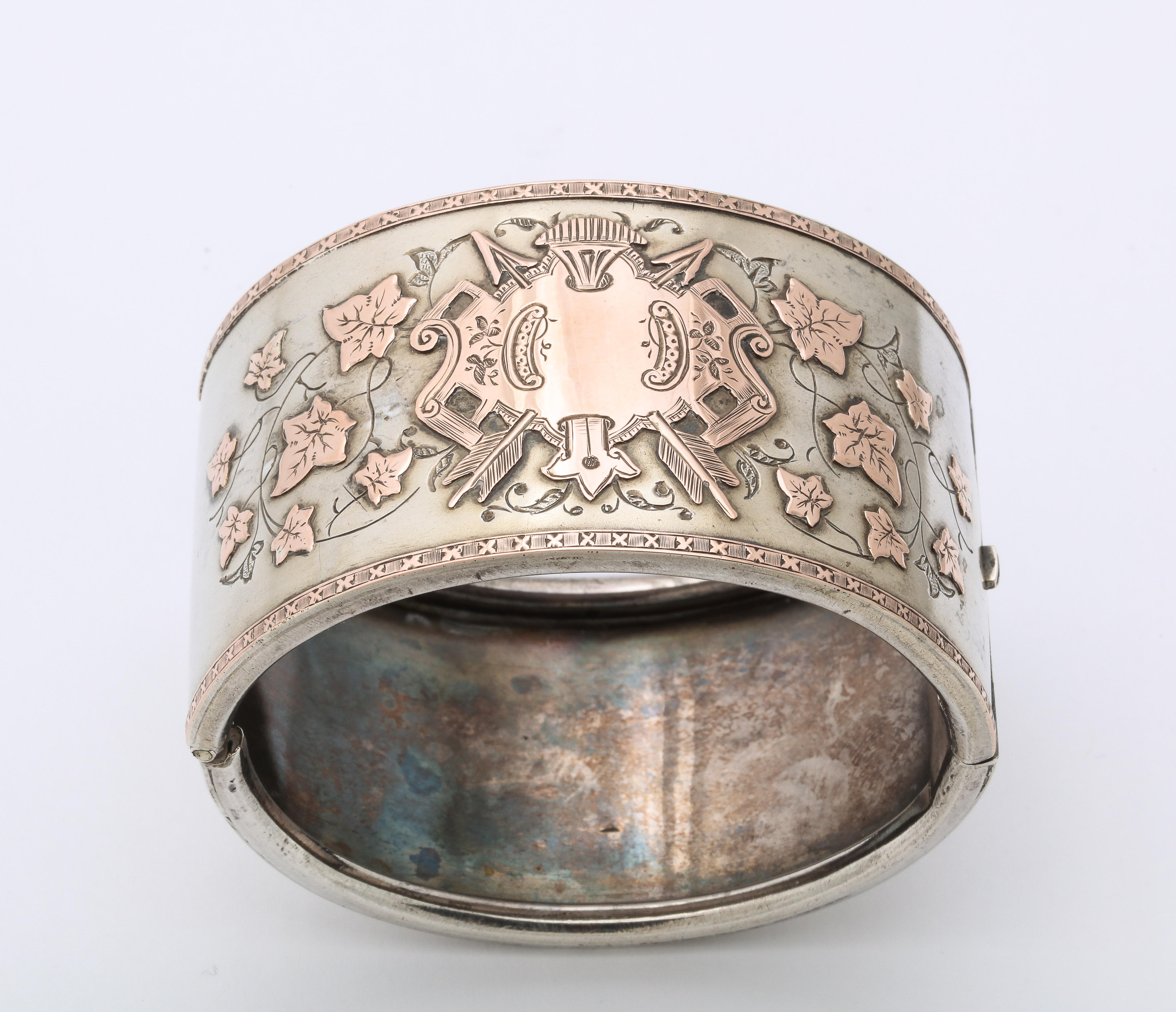 A refined and rare silver Victorian Cuff, elegant and grand, is floridly engraved with a gold washed shield and ivy leaves. The shield is so strong that it had to have been that of an aristocratic family with strong family ties, shown by the ivy