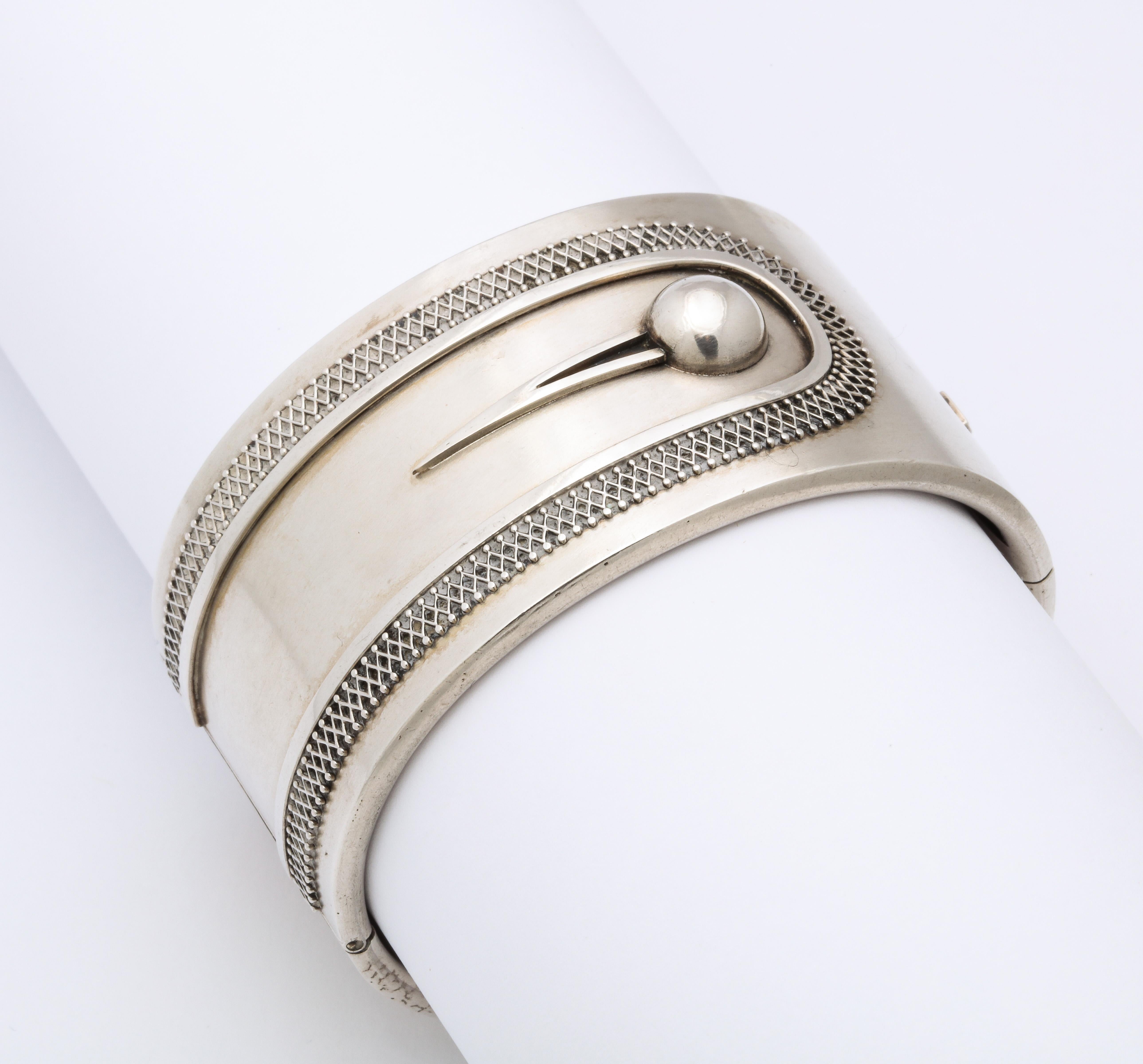 The simplicity of this silver button cuff bracelet makes the contrast in texture a standout. Diamond formed architectural wire work surrounds the button strap. I fell in love with the positive negative space that for some reason gives pleasure every
