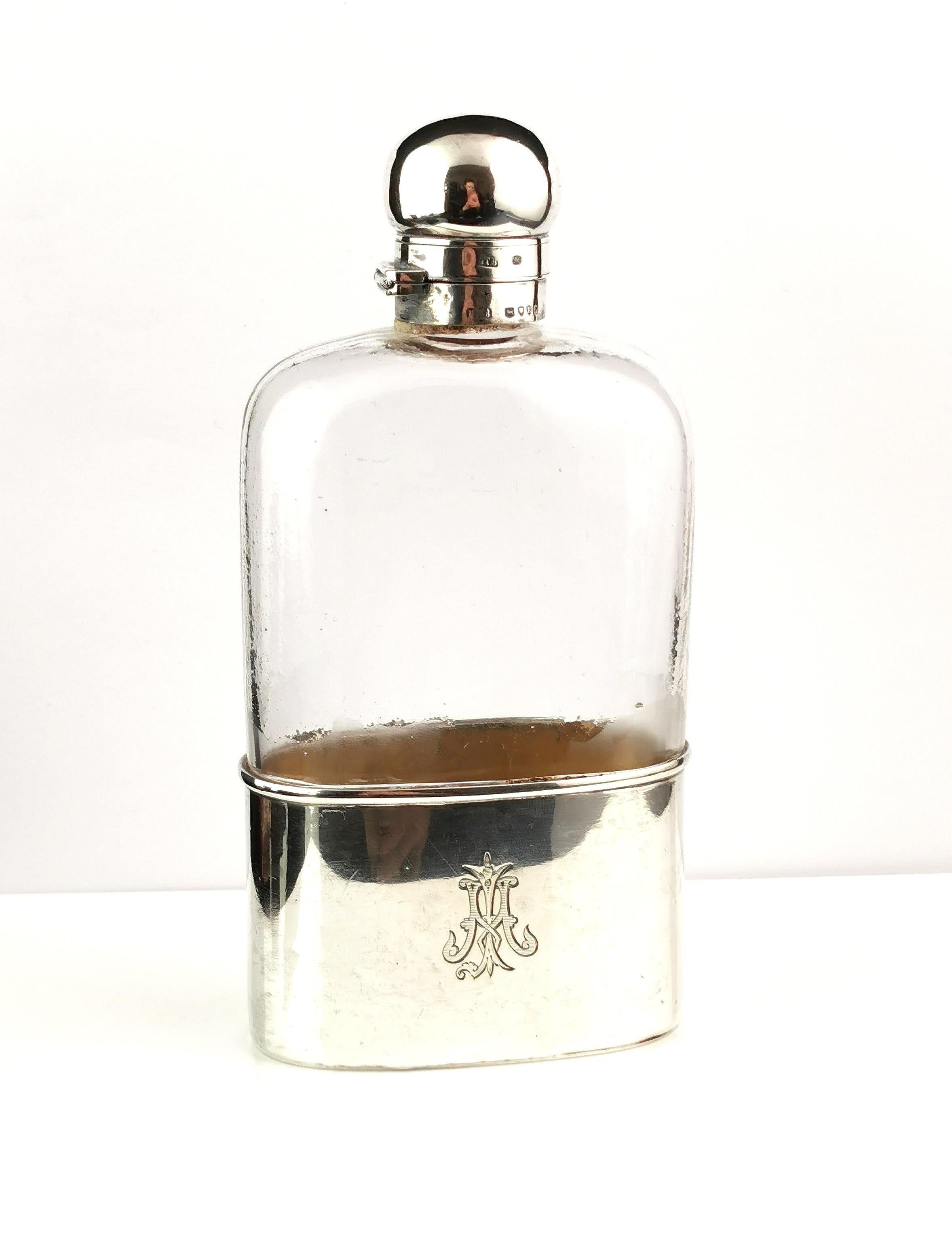A handsome antique, sterling silver and glass hip flask.

Victorian era this substantial hip flask is made from glass with a sterling silver bayonet cap, Cork lined.

It has a sleek sterling silver beaker base, this can be removed to be used as a