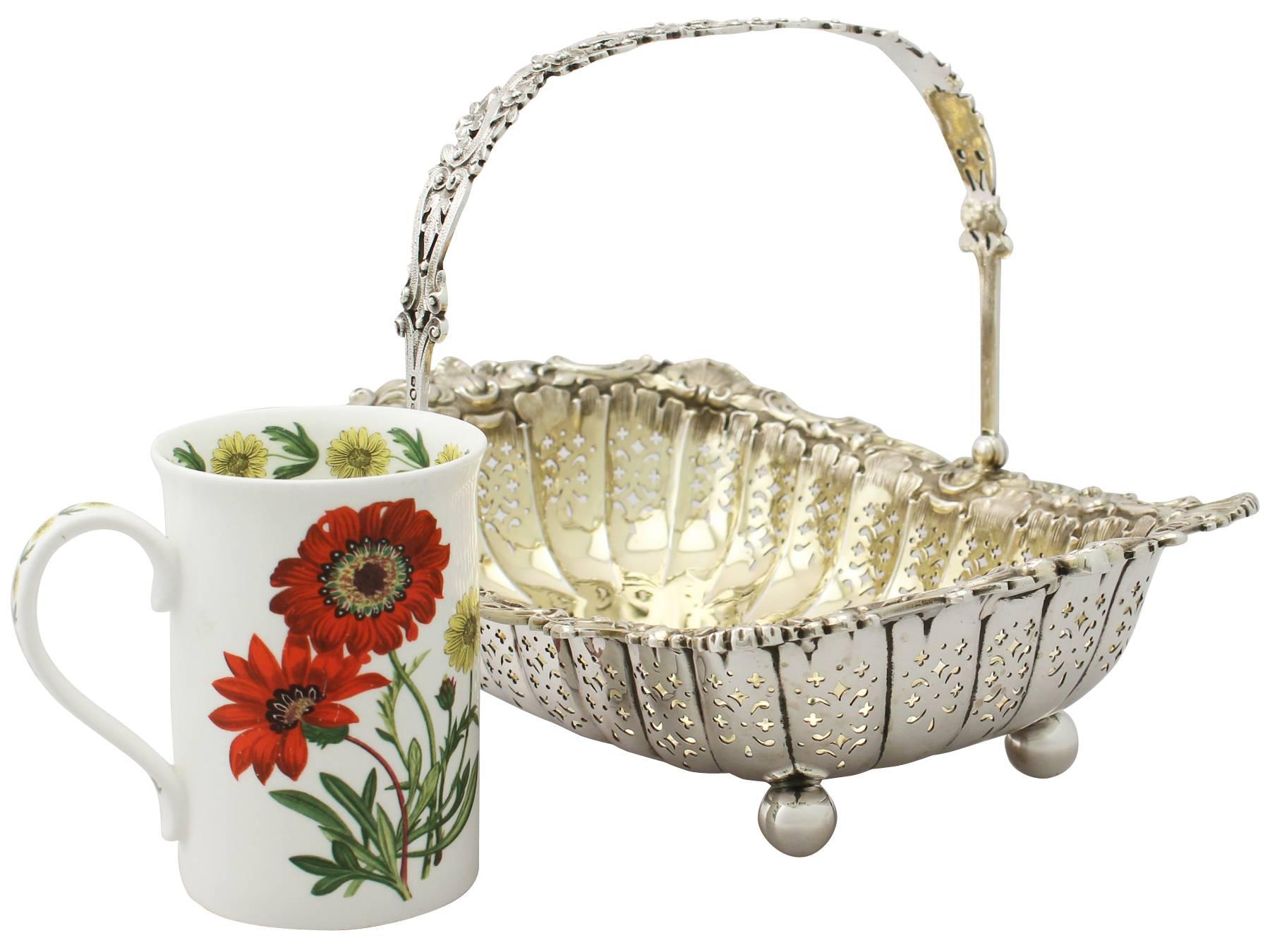 A fine and impressive antique Victorian English sterling silver swing handled basket by James Dixon & Sons Ltd; part of our ornamental silverware collection.

This antique Victorian sterling silver basket has a rectangular rounded form onto four
