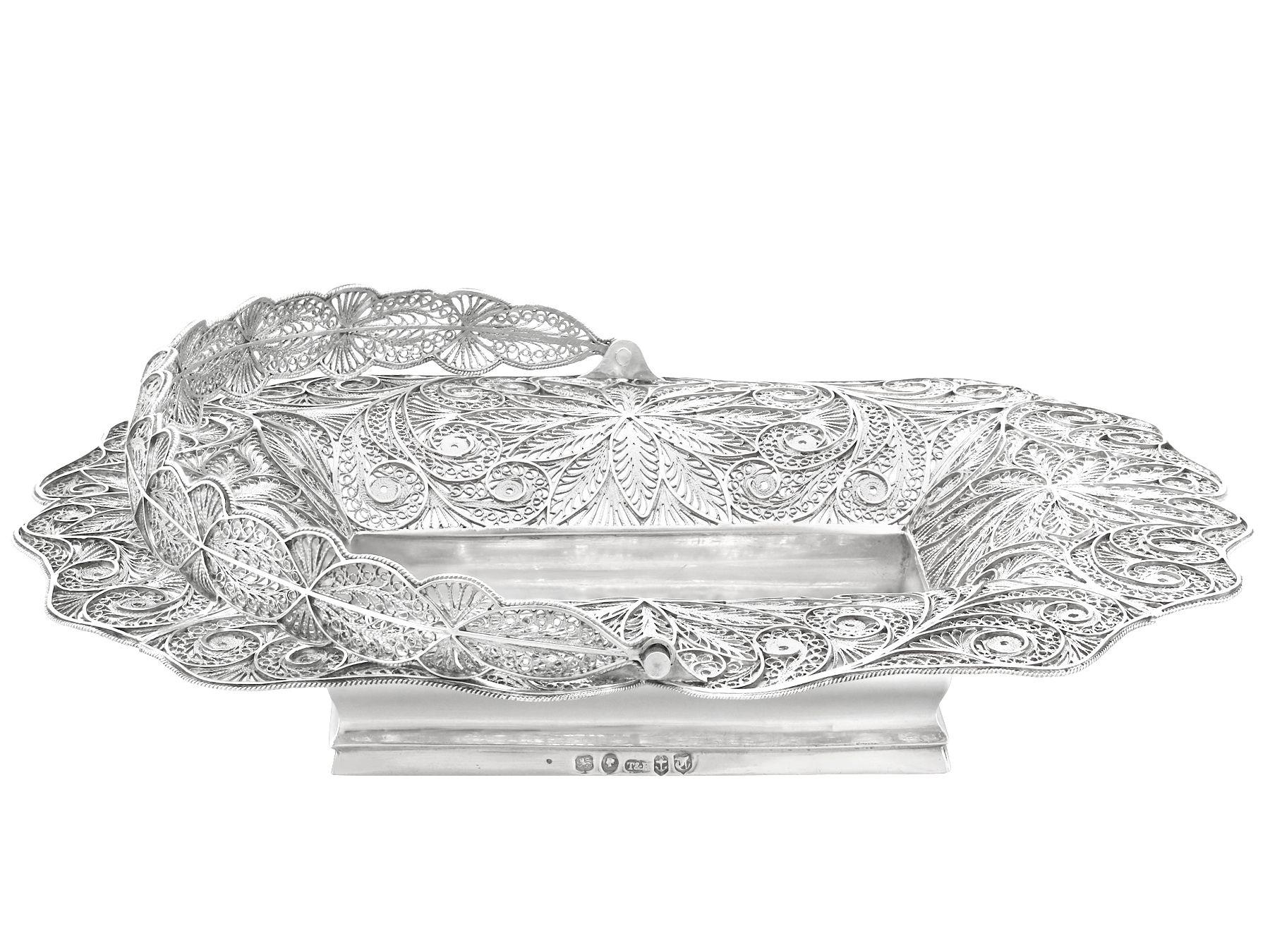 An exceptional, fine and impressive and rare antique Victorian English sterling silver swing handled bon bon basket; an addition to our ornamental silverware collection.

This fine antique Victorian sterling silver basket has an oval shaped form