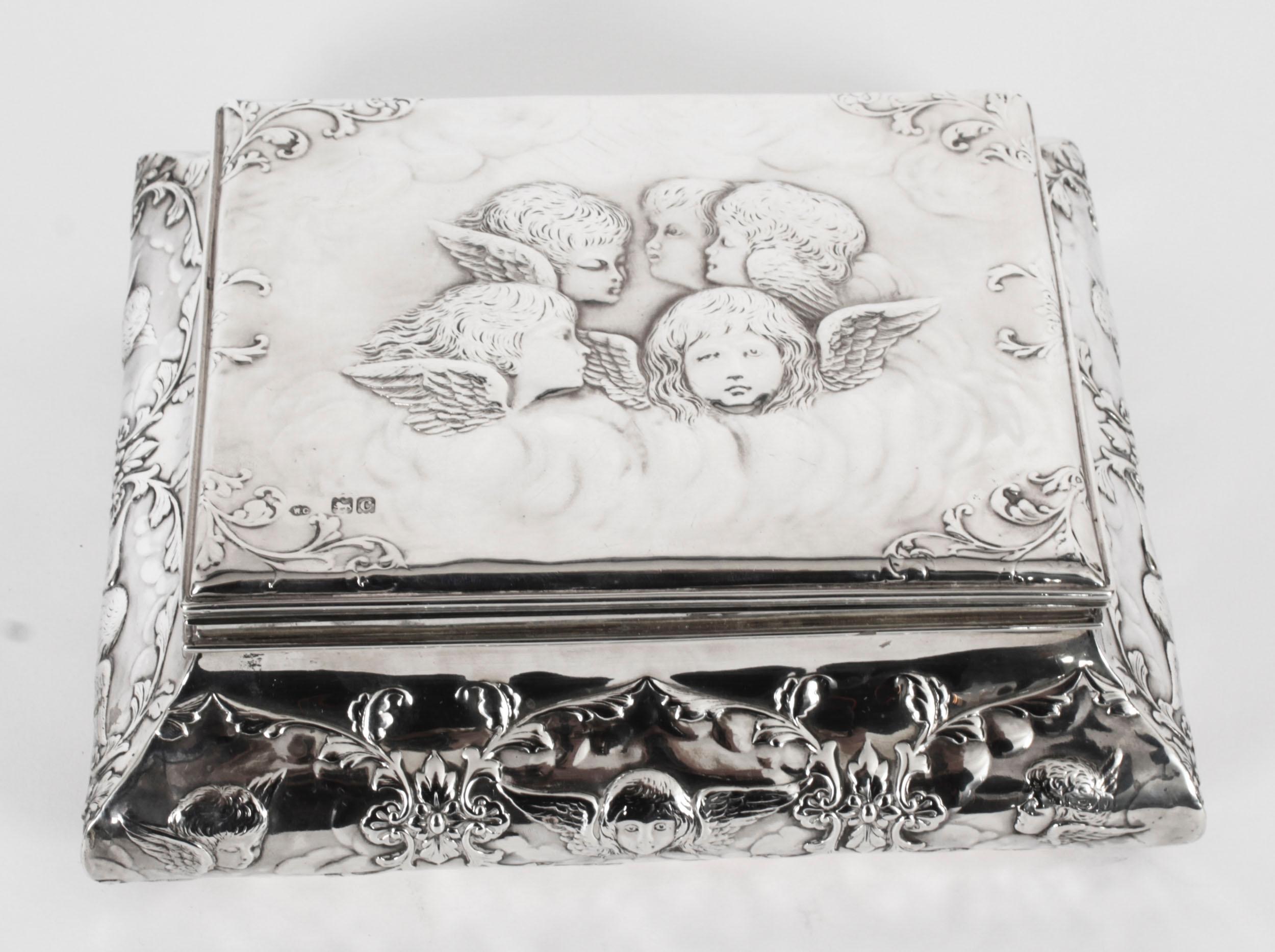 This is an elegant antique Victorian sterling silver casket with hallmarks for London, 1898 and the makers marks of the renowned silversmith William Comyns & Sons.

The shaped casket feaures a hinged cover with repousse Reynolds Angels portrait and