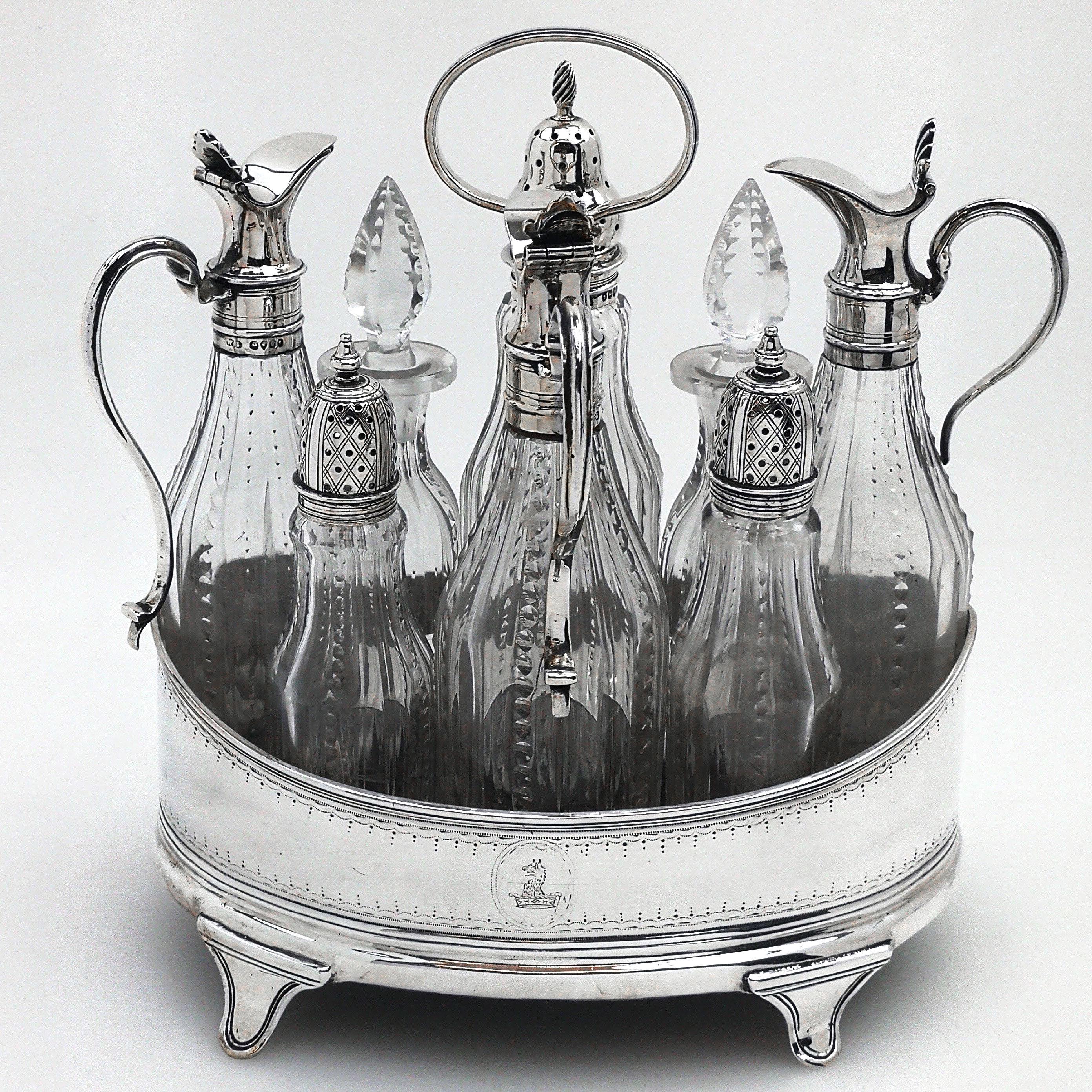 A lovely antique Victorian solid Silver cruet set in an oval stand. The cruet stand has an upwardly curved rim with a reeded band applied and features a subtle engraved design around the upper and lower rims, and a matched pair of crests engraved.