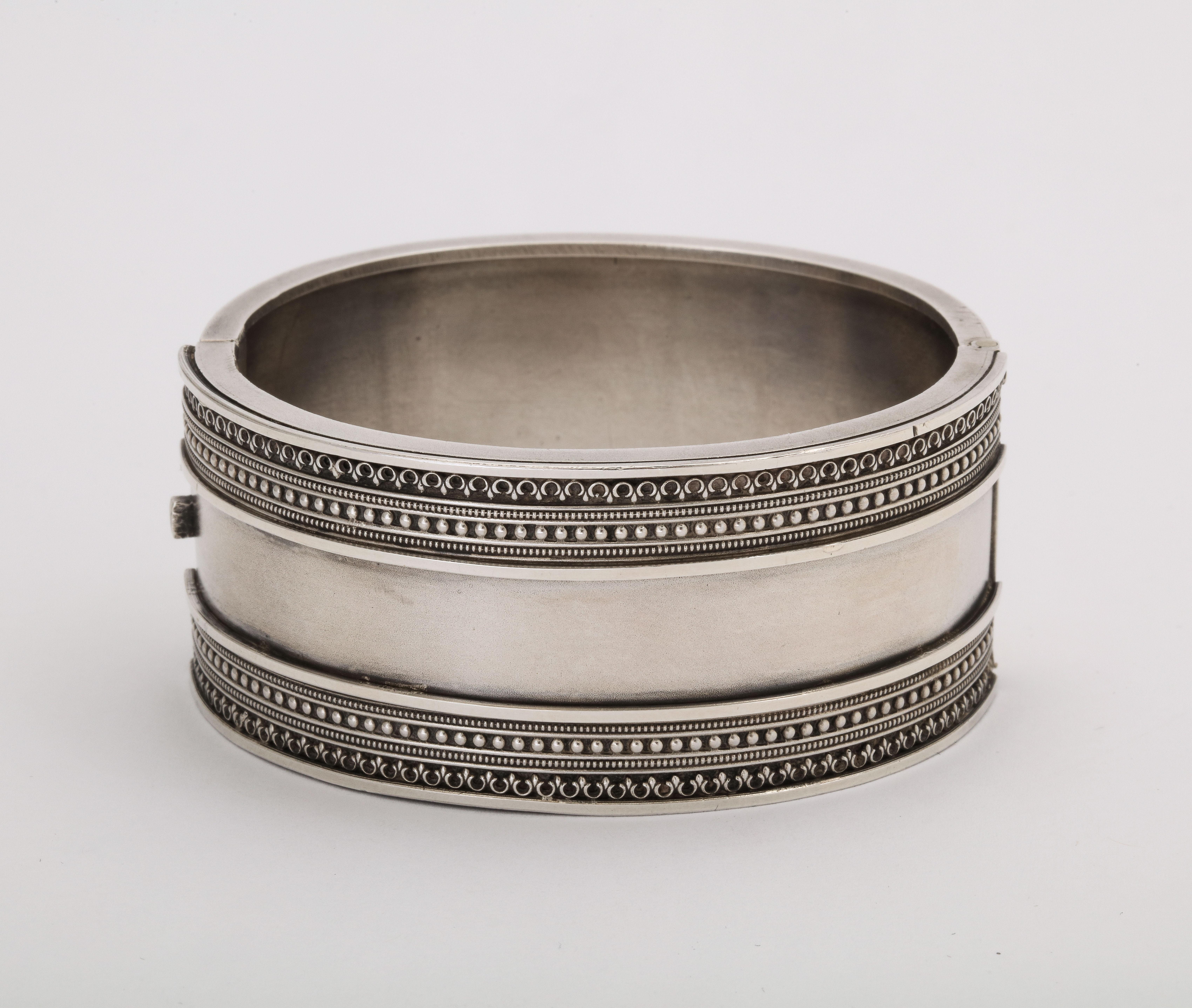 Victorian Silver bloomed in popularity from 1860-1880 and this elegant, unscathed cuff was made during that period. The center of this cuff is plain with no scratch or dent and that plainness contrasts with the embellished architecural patterns top