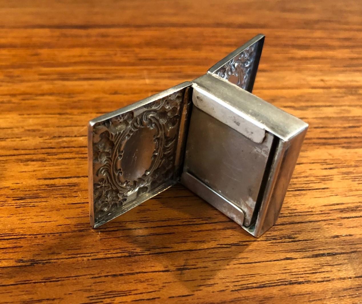 A fine quality Victorian sterling silver double sided stamp box by Whiting Manufacturing Co. of New York, circa 1900. The piece is of rectangular form with richly engraved repousse top and bottom and is spring loaded on both sides and hallmarked as