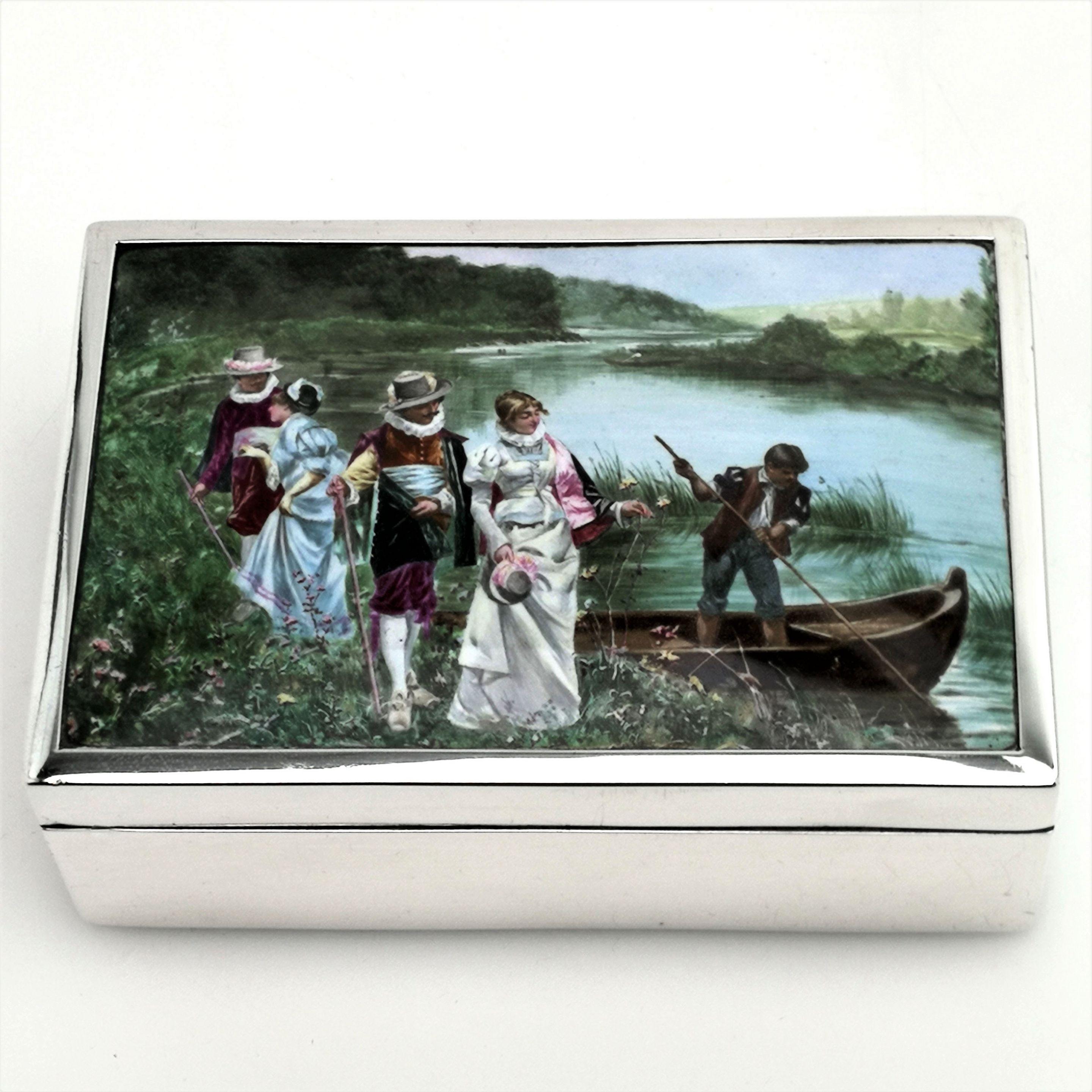 A beautiful Antique Victorian solid Silver and Enamel Box with a magnificent enamel panel on the lid. The panel shows two women dressed in white with two gentlemen walking on a river bank with a boatman on the water. The image is created in deep,