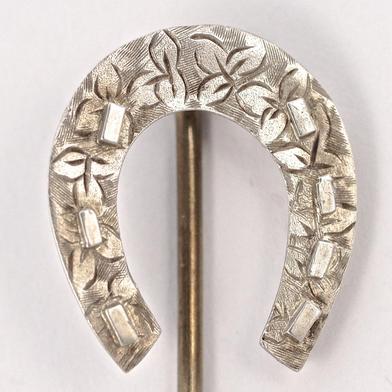 Wonderful antique Victorian sterling silver horseshoe stick pin, featuring a lovely floral hand engraved design. It has seven nails, four on one side and three on the other, seven being the luckiest number. The horseshoe is silver, the pin is not.