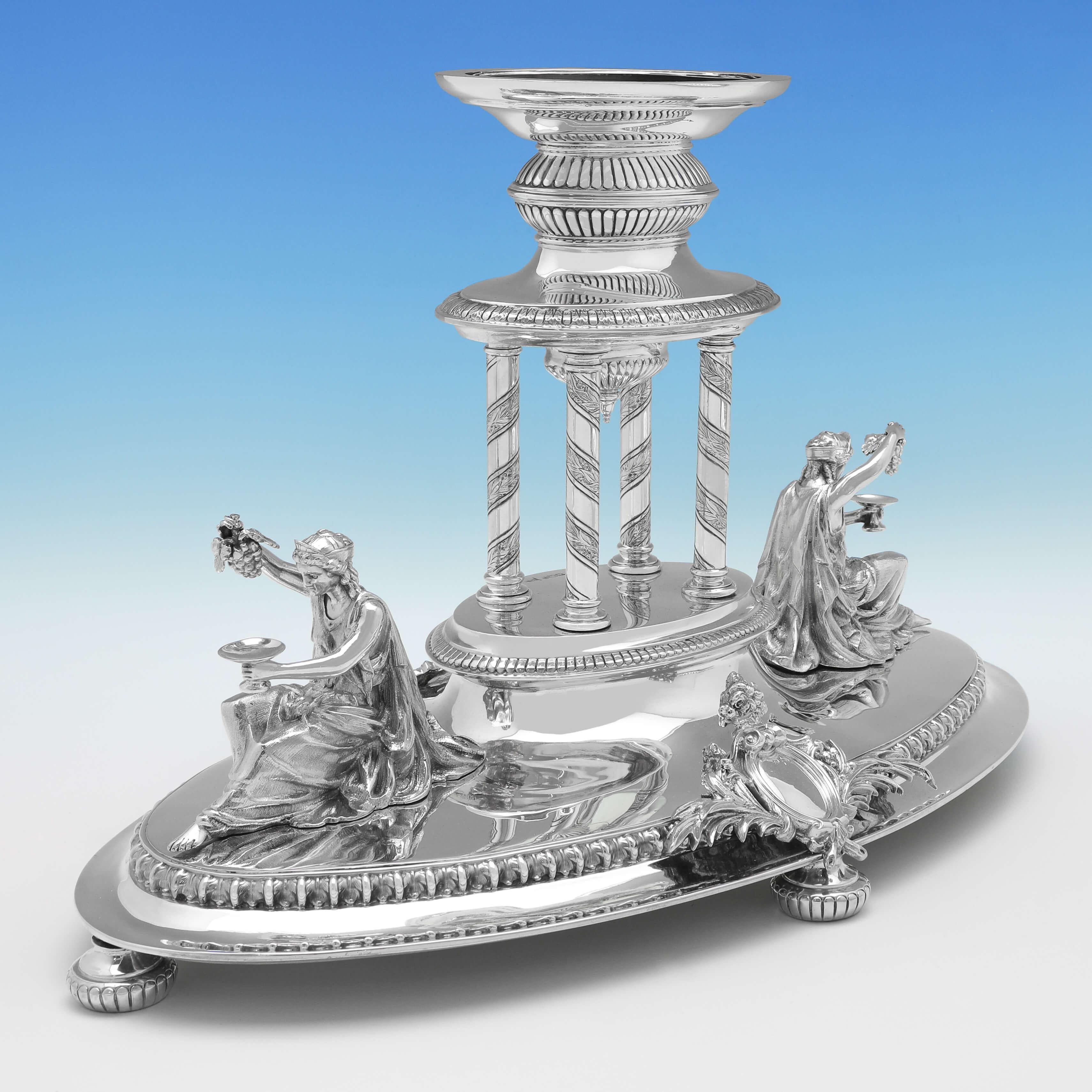 Hallmarked in Sheffield in 1897 by Walker & Hall, this exceptional, Victorian, antique sterling silver centrepiece, features a removable central bowl supported by four neoclassical columns, surmounted on an oval base adorned to both ends with