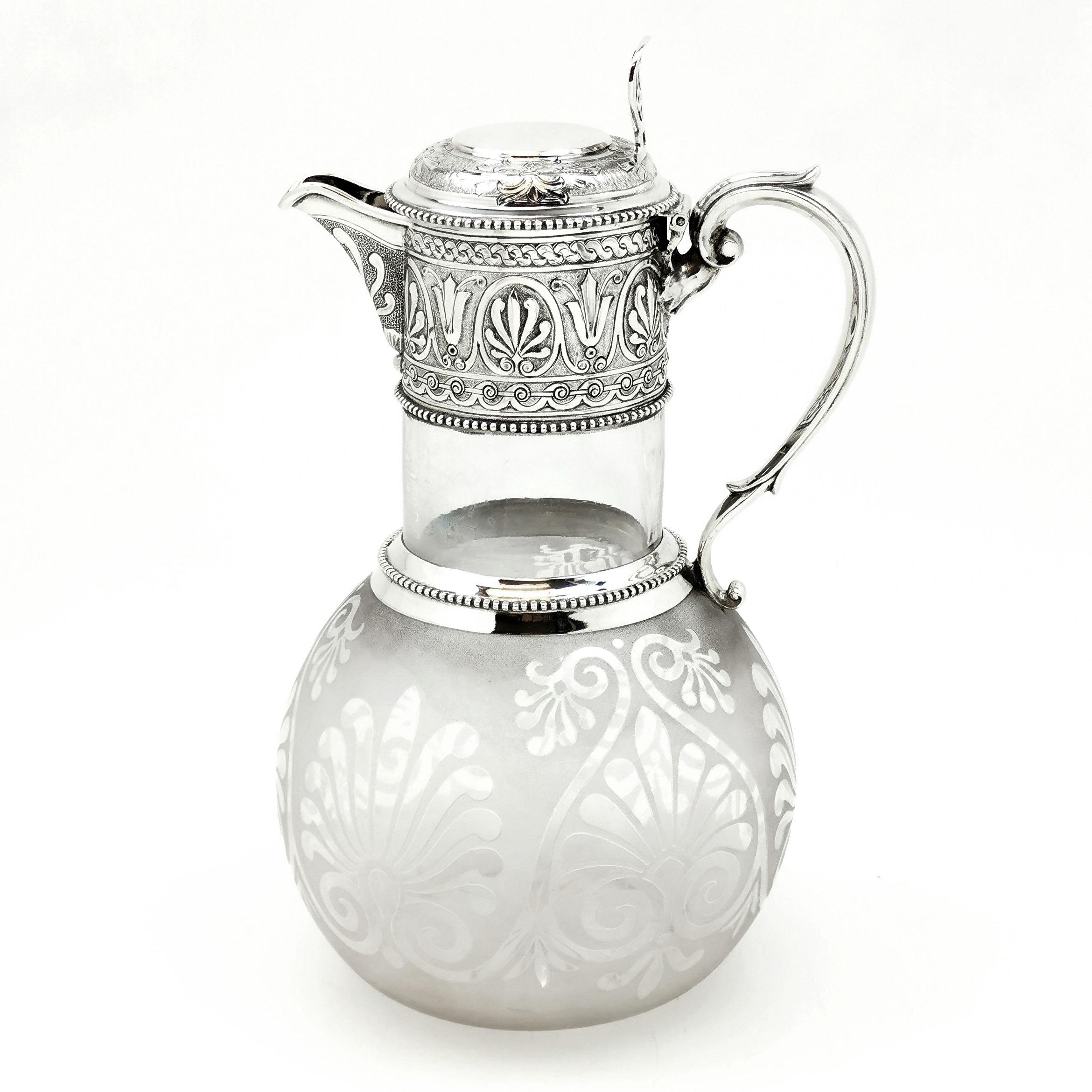 A lovely Antique Victorian Solid Silver Mounted Claret Jug with an elegant frosted glass body. The round Glass body has a delicate pattern frosted over the entire exterior. The Silver Neck and lid feature delicate chased patterns and one side of the