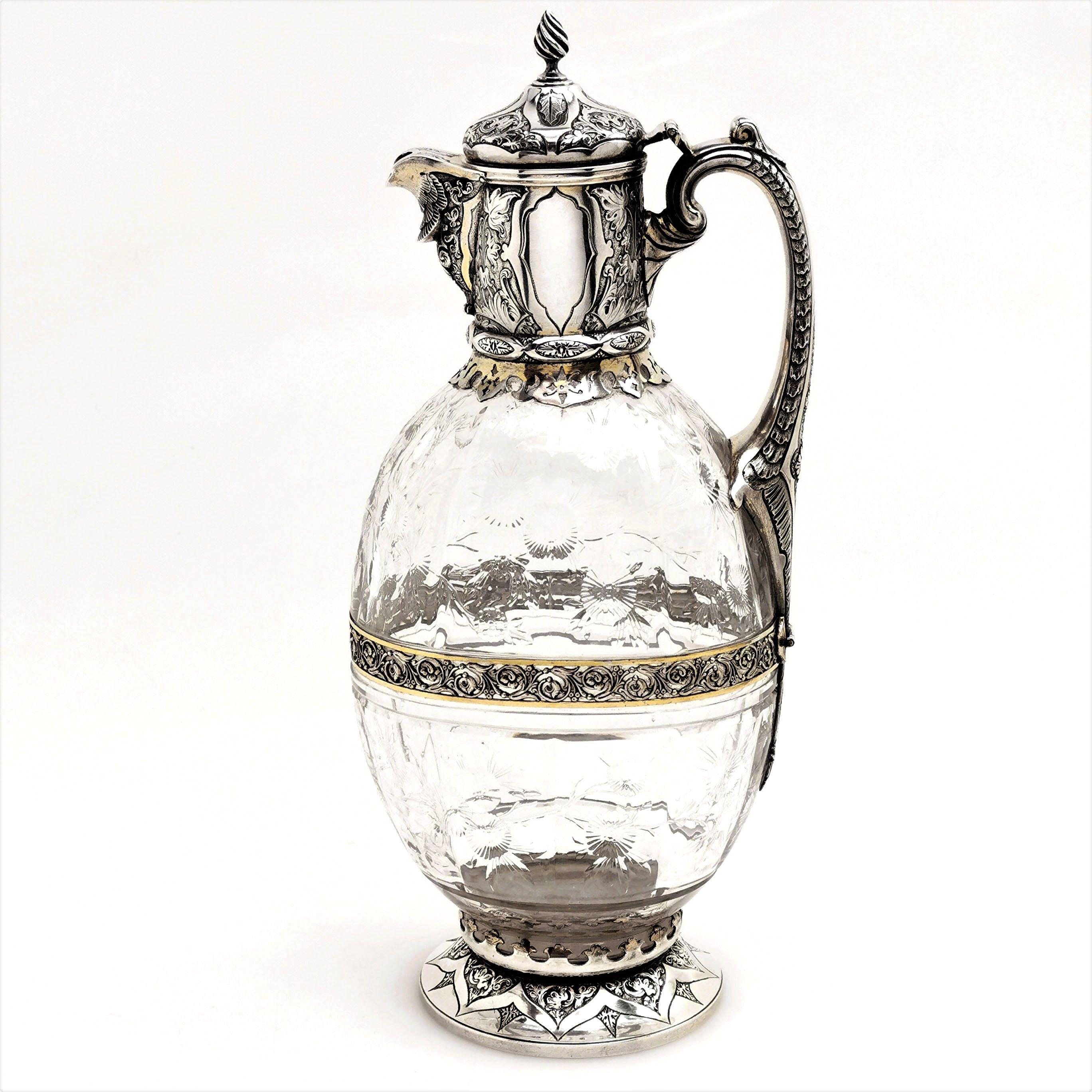 A beautiful antique Victorian Silver and parcel-gilt cut Glass Claret Jug or Wine Decanter.
The body of the Jug is cut in a lovely floral pattern and the silver is embellished with a chased design surrounding a pair of cartouches. 
 
 Made in London