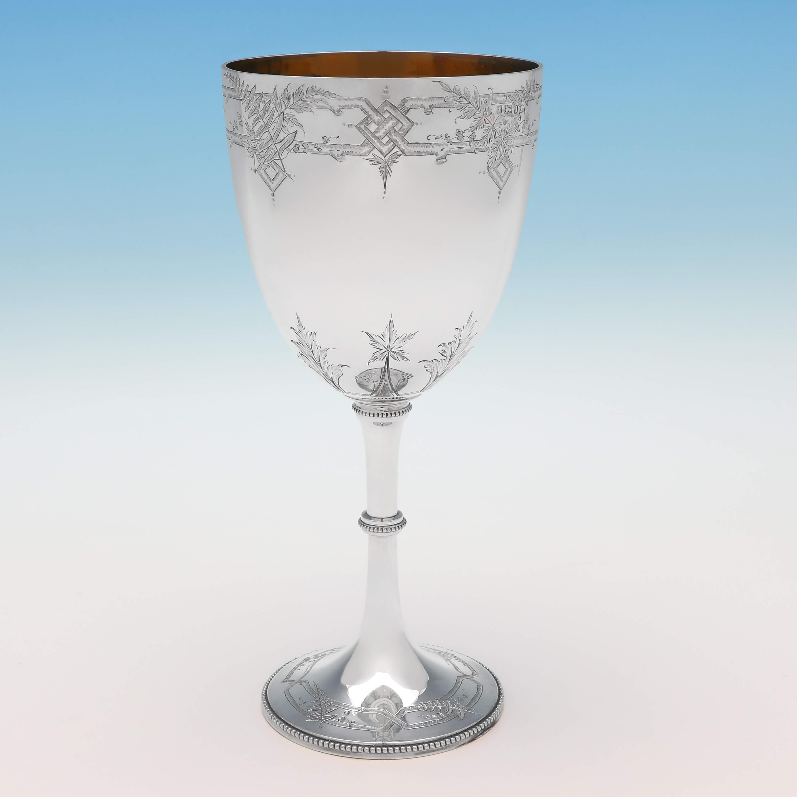 Hallmarked in Sheffield in 1876 by Fenton Brothers Ltd., this very attractive, Victorian, antique sterling silver goblet, features engraved bands of naturalistic detailing, bead borders, and a gilt interior. The goblet measures 8