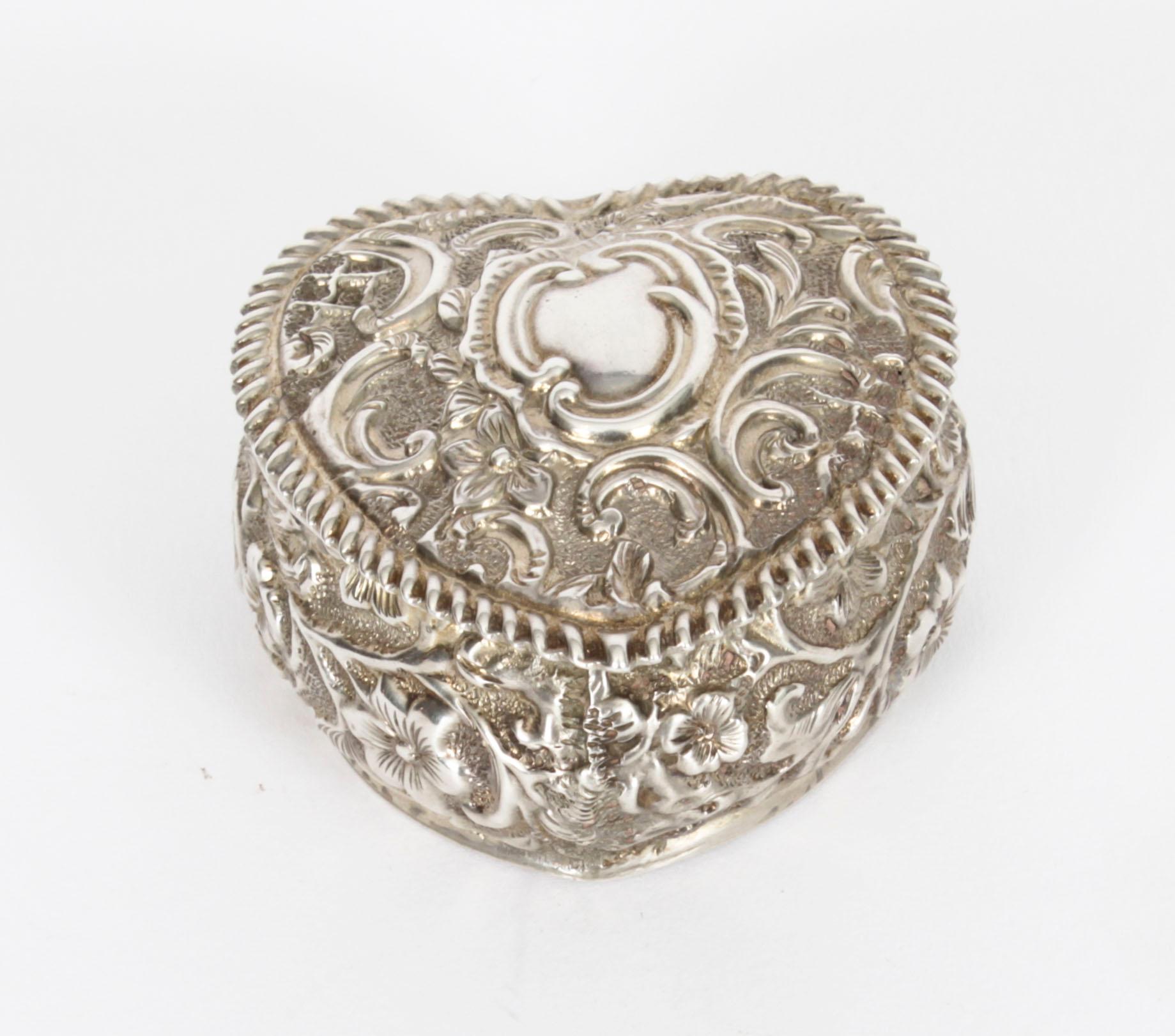 This is an exquisite antique Victorian sterling silver heart shaped pill box with hallmarks for Birmingham 1896 and the makers mark of the silversmith Henry Matthews.

The pill box is of heart shaped form with embossed foral decoration, it has a