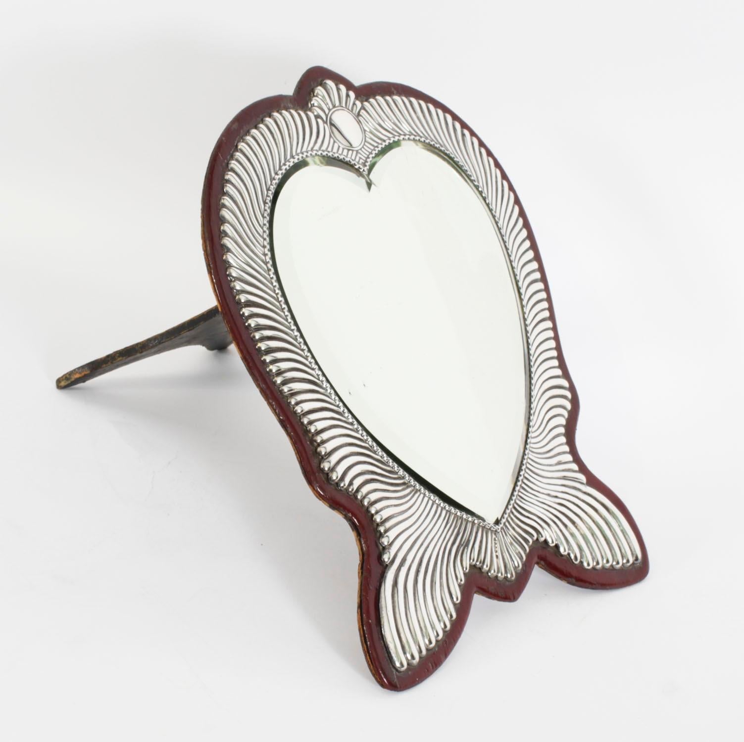 Il s'agit d'un fabuleux miroir de coiffeuse de style victorien en argent sterling en forme de cœur, portant les poinçons de Londres 1888 et la marque du fabricant, GH pour Harrison Brothers & Howson.

La bordure cannelée est surmontée d'un cartouche