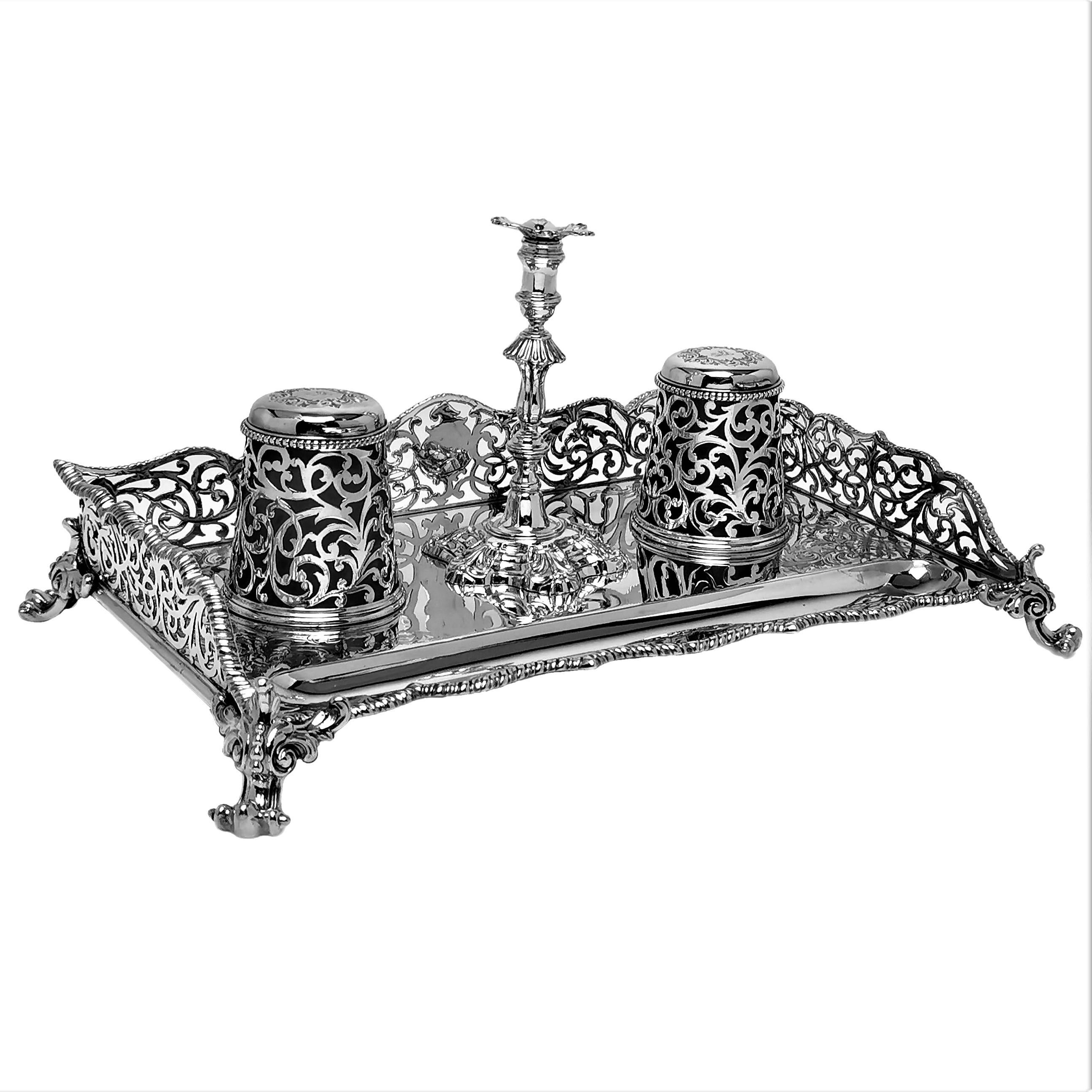 A beautiful Antique Victorian solid Silver Inkstand with two fitted glass lined Inkwells and a removable taper candlestick. The body of the inkwell has an elegant pierced design on the sides mirrored on the bodies of the inkwells. The base of the