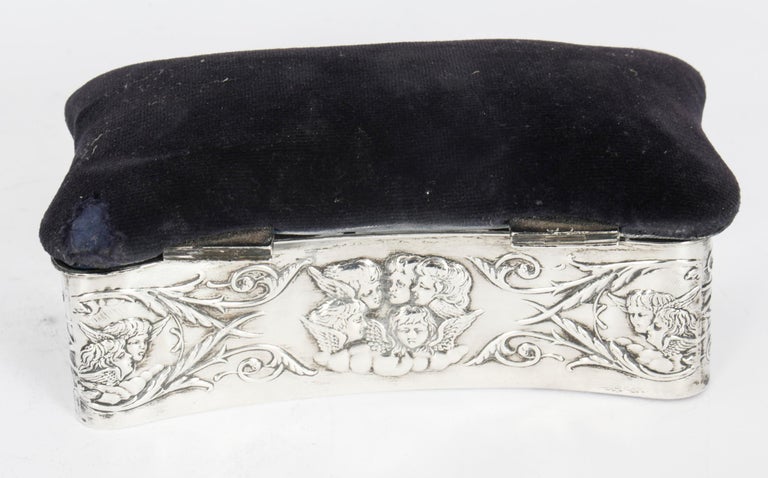 This is a lovely antique Victorian sterling silver jewellery casket / pin cushion bearing the makers mark of H.Matthews, and hallmarks for Birmingham 1899.
 
The hinged lid is fitted with a navy velvet pin cushion. The rectangular casket is chased