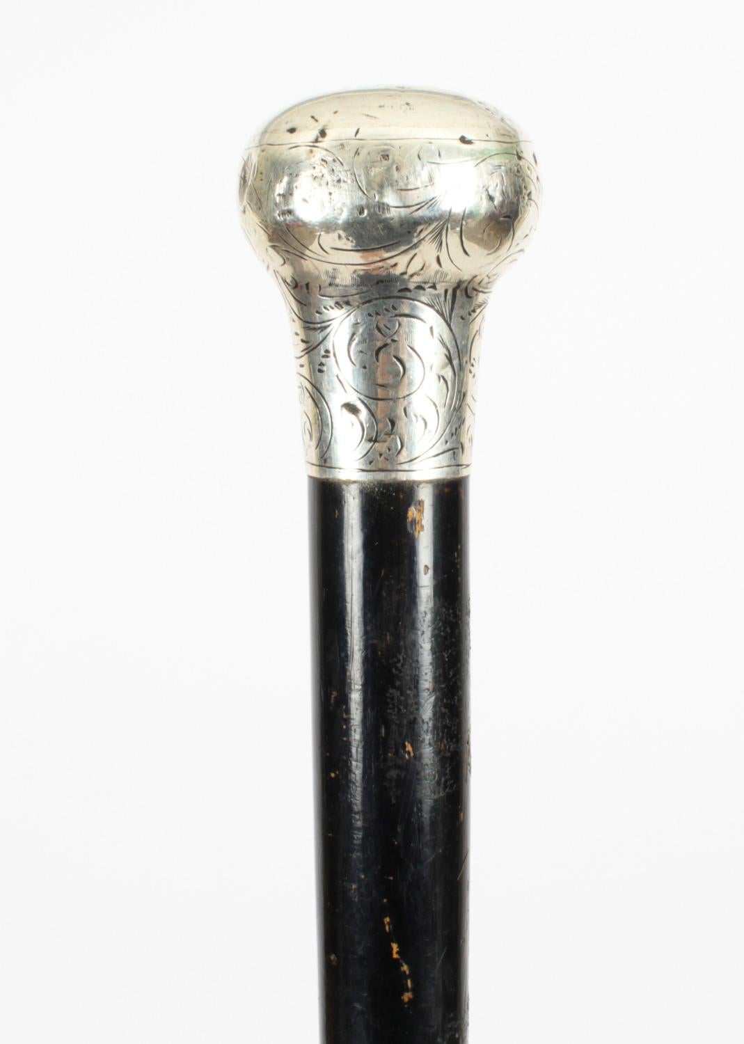This is a beautiful antique Victorian sterling silver pommel and ebonised shaft walking stick with hallmarks for Birmingham, dated 1871.
 
This decorative walking cane features an exquisite cast silver pommel with engraved decoration. It has a