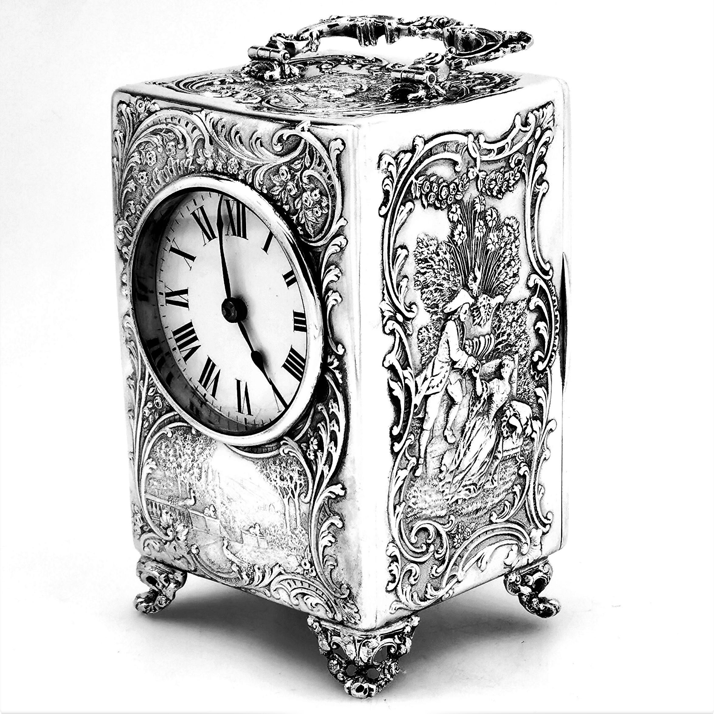 A pretty antique Victorian solid Silver Carriage Clock. This Victorian Clock has an elegantly chased body with all four sides and the top showing period scenes of figures in a country setting. The Silver Clock has a white face with black roman