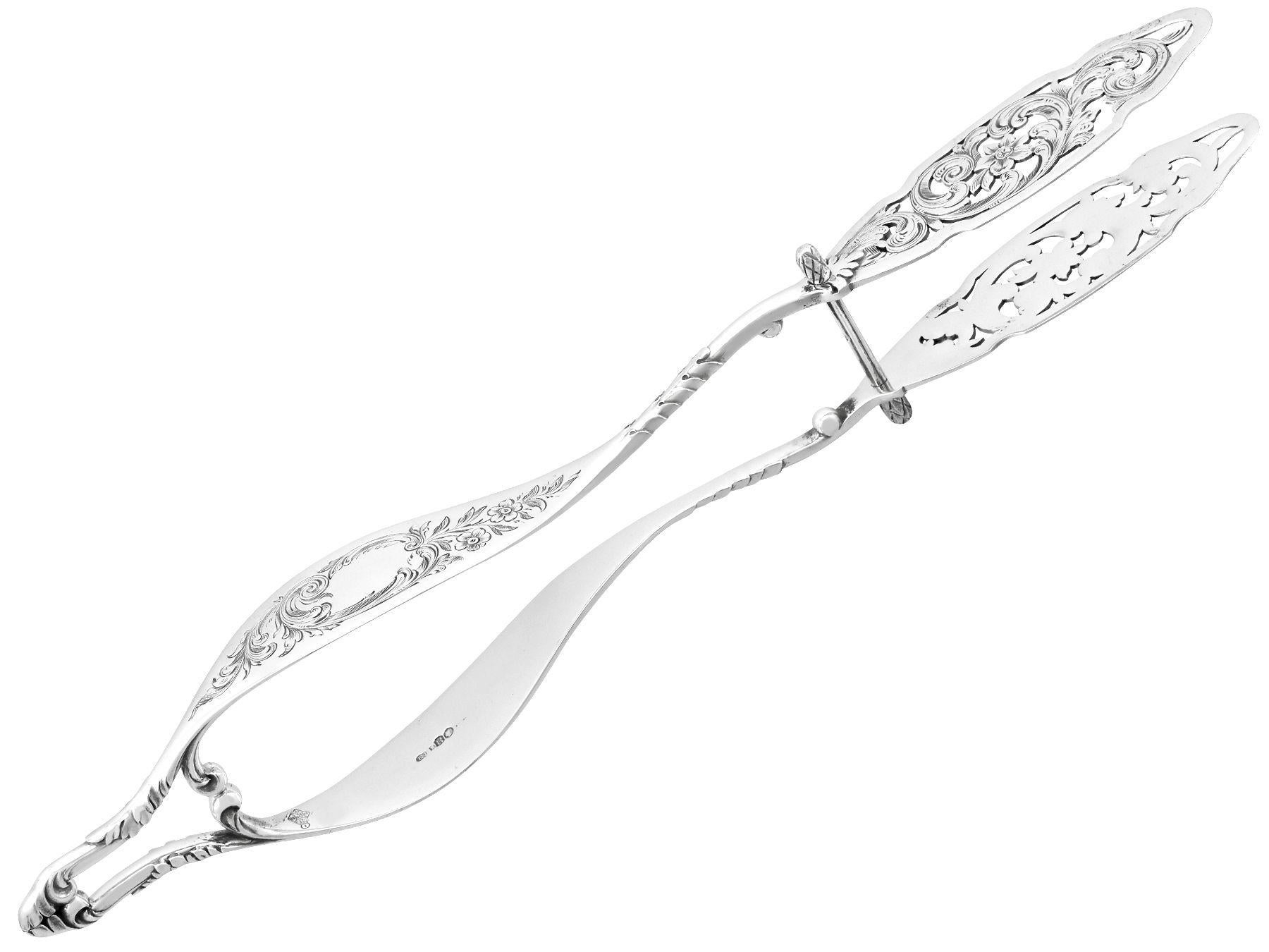 An exceptional, fine and impressive, large pair of antique Victorian English sterling silver serving tongs; an addition to our silver flatware collection.

These exceptional antique Victorian large sterling silver tongs have an oval shaped