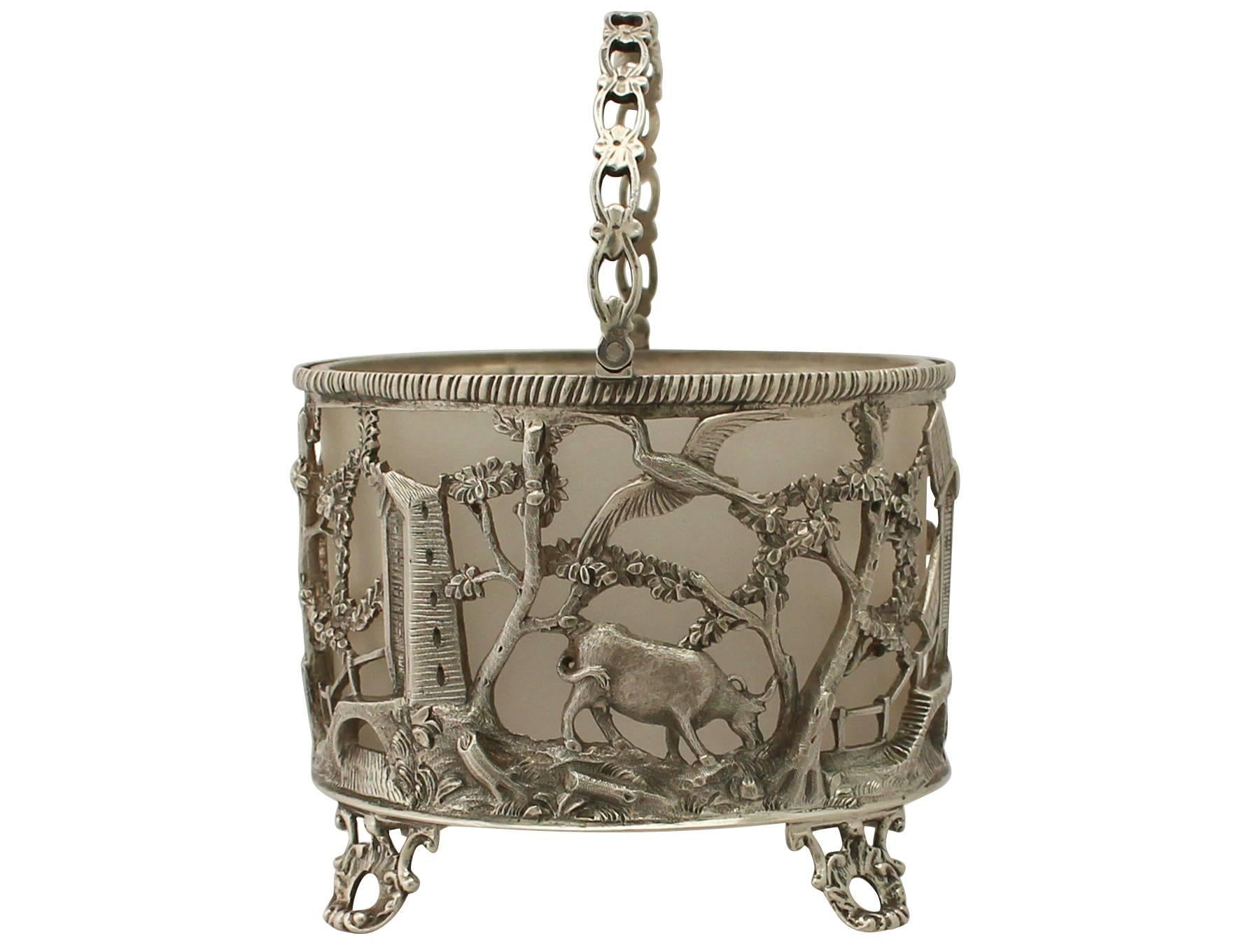 An exceptional, fine and impressive antique Victorian English sterling silver sugar basket; an addition to our silver teaware collection.

This exceptional antique sterling silver basket has a cylindrical shaped form onto four bracket style